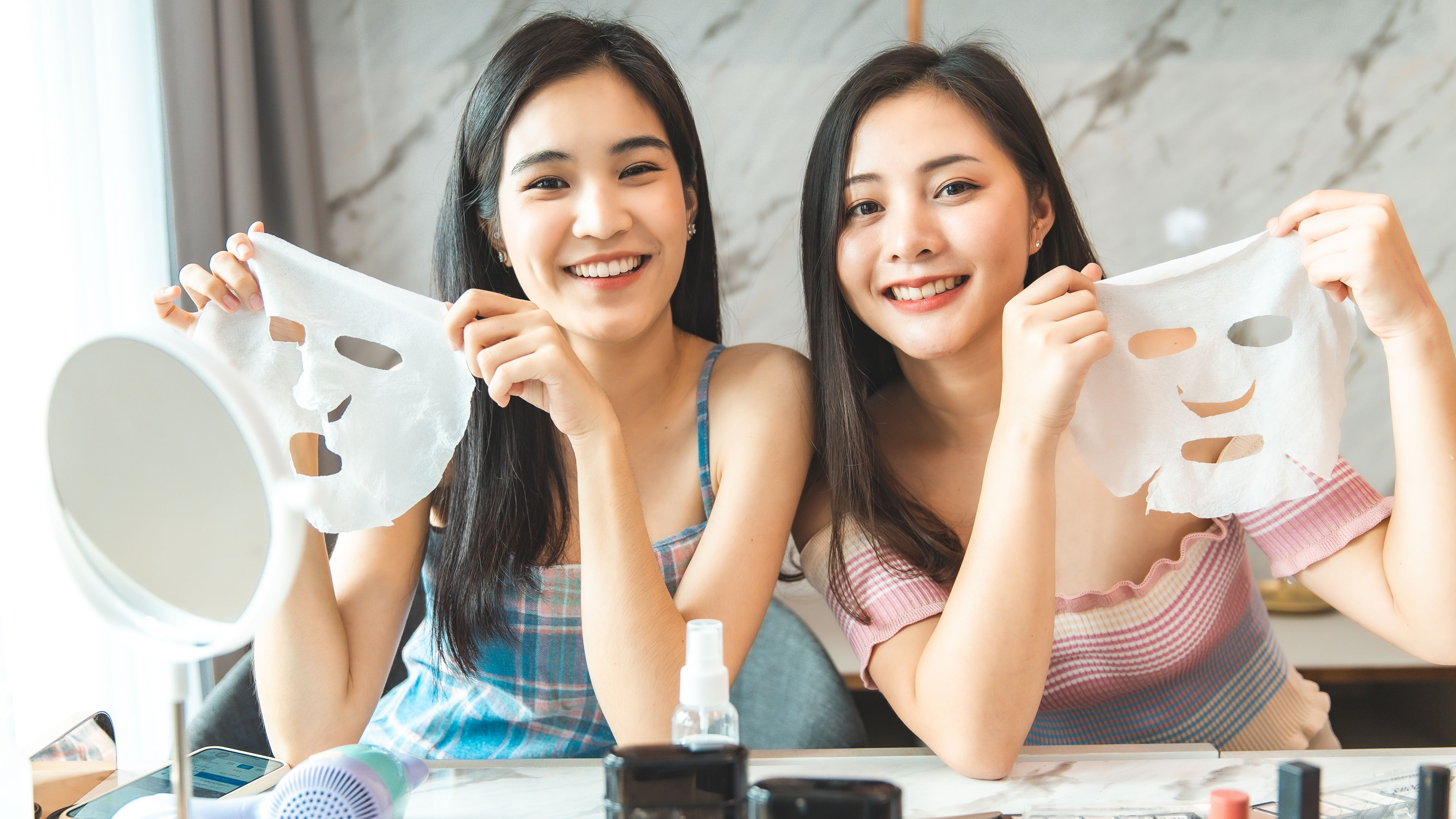 Two Asian girls are using beauty products