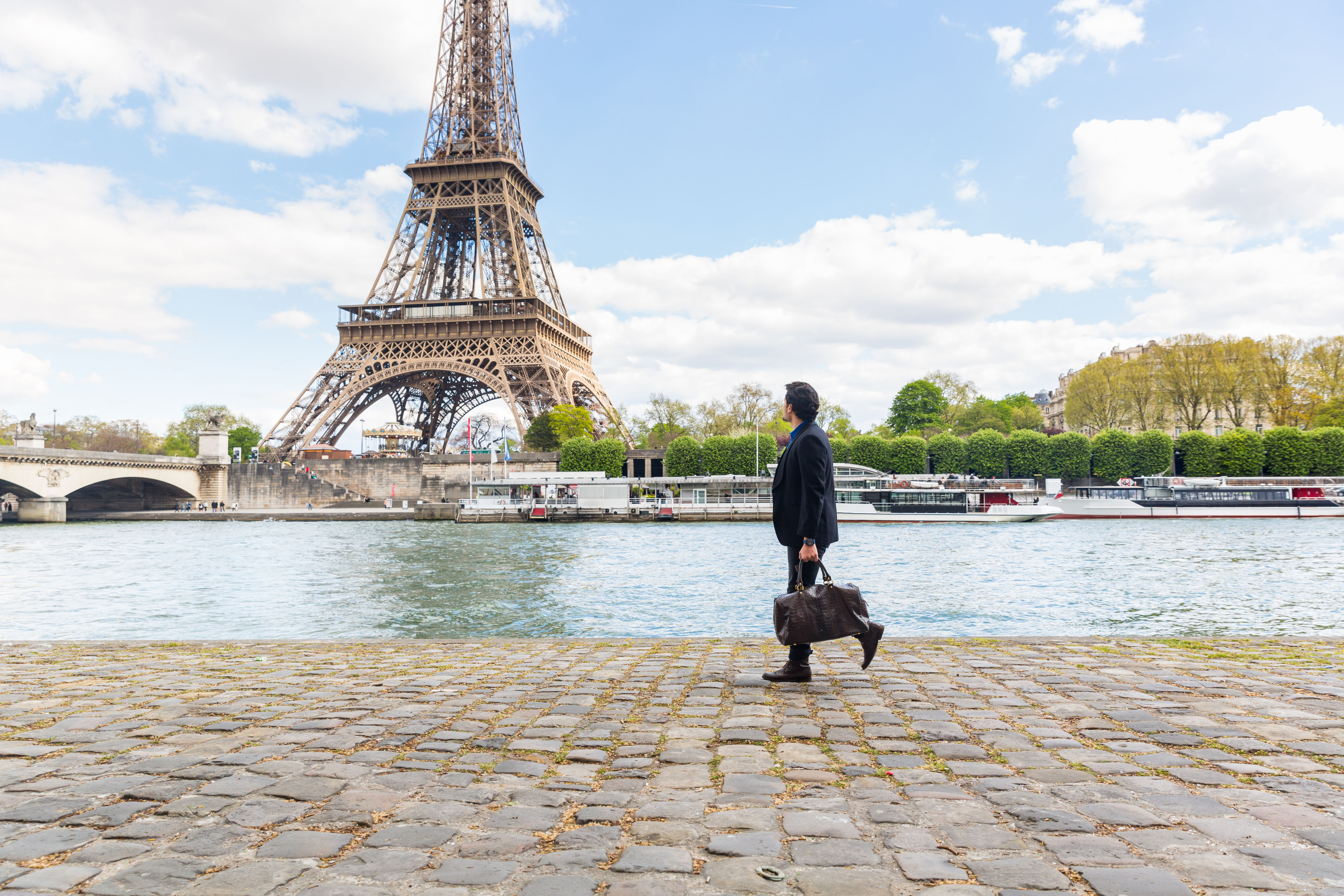 A businessman is leaning on a bridge
