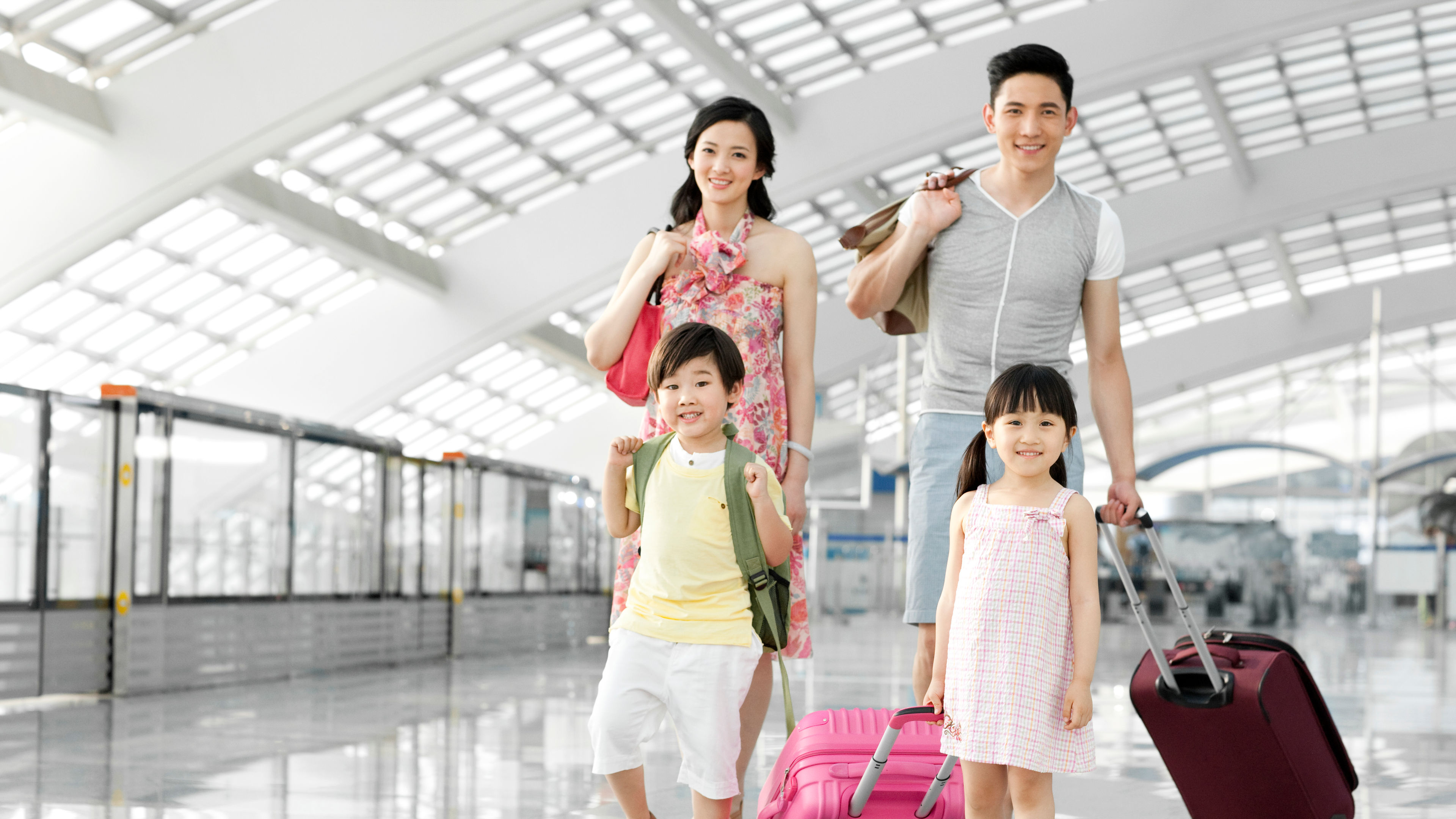 A happy family is walking through a airport