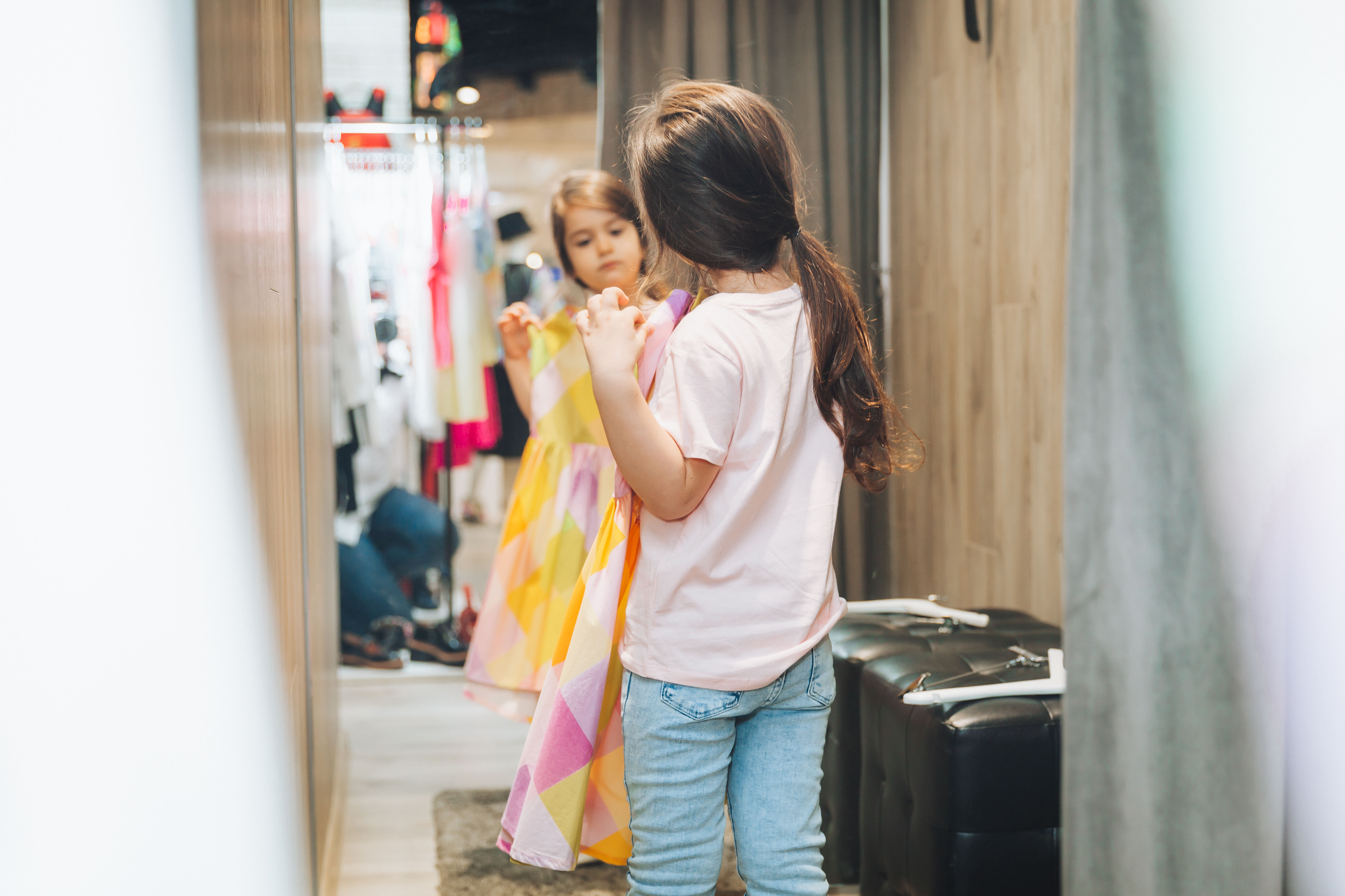 The mother and daughter share a fun shopping experience as they pick out and try vibrant dresses 