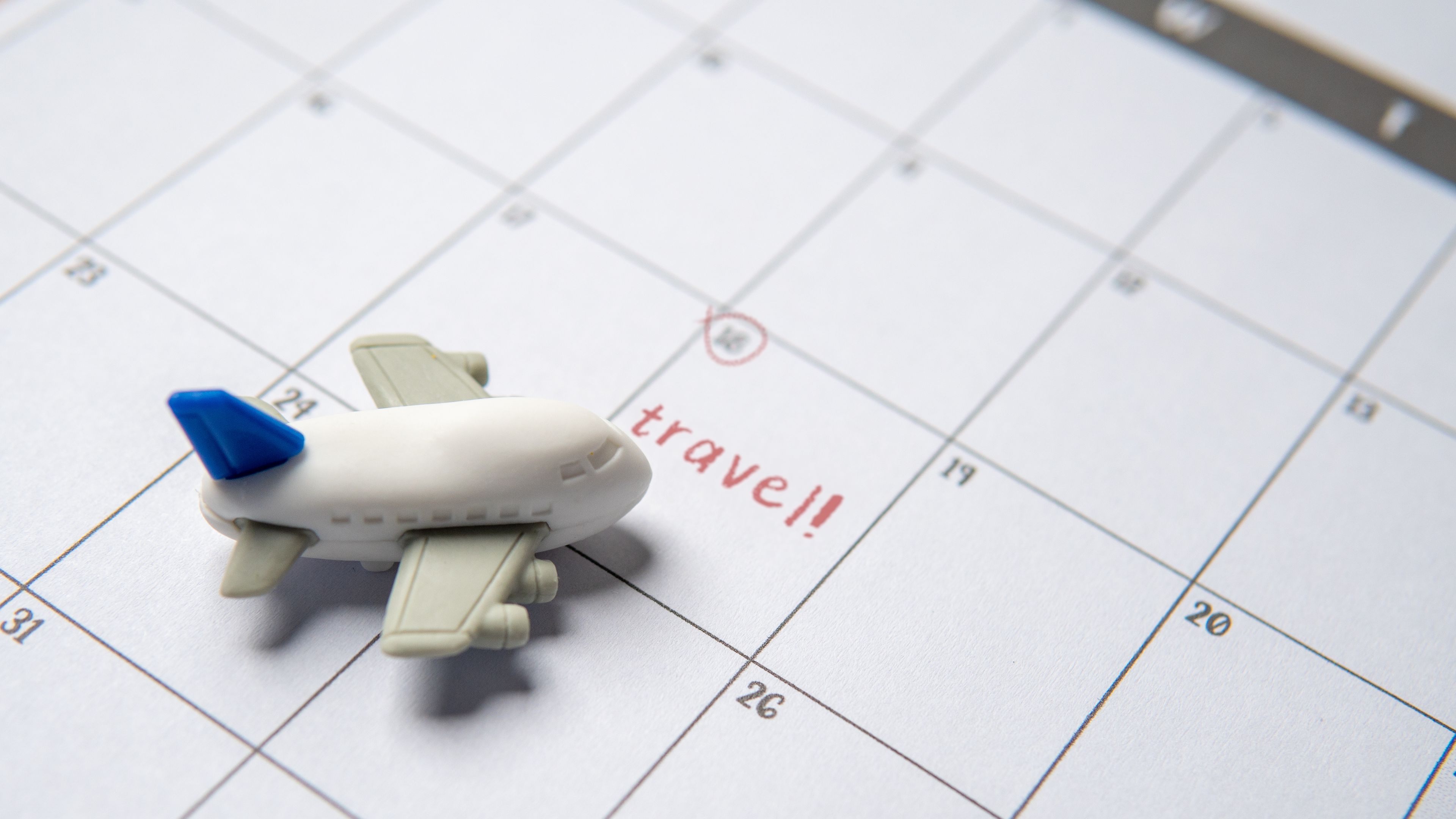 A small toy airplane is placed on top of a calendar page 