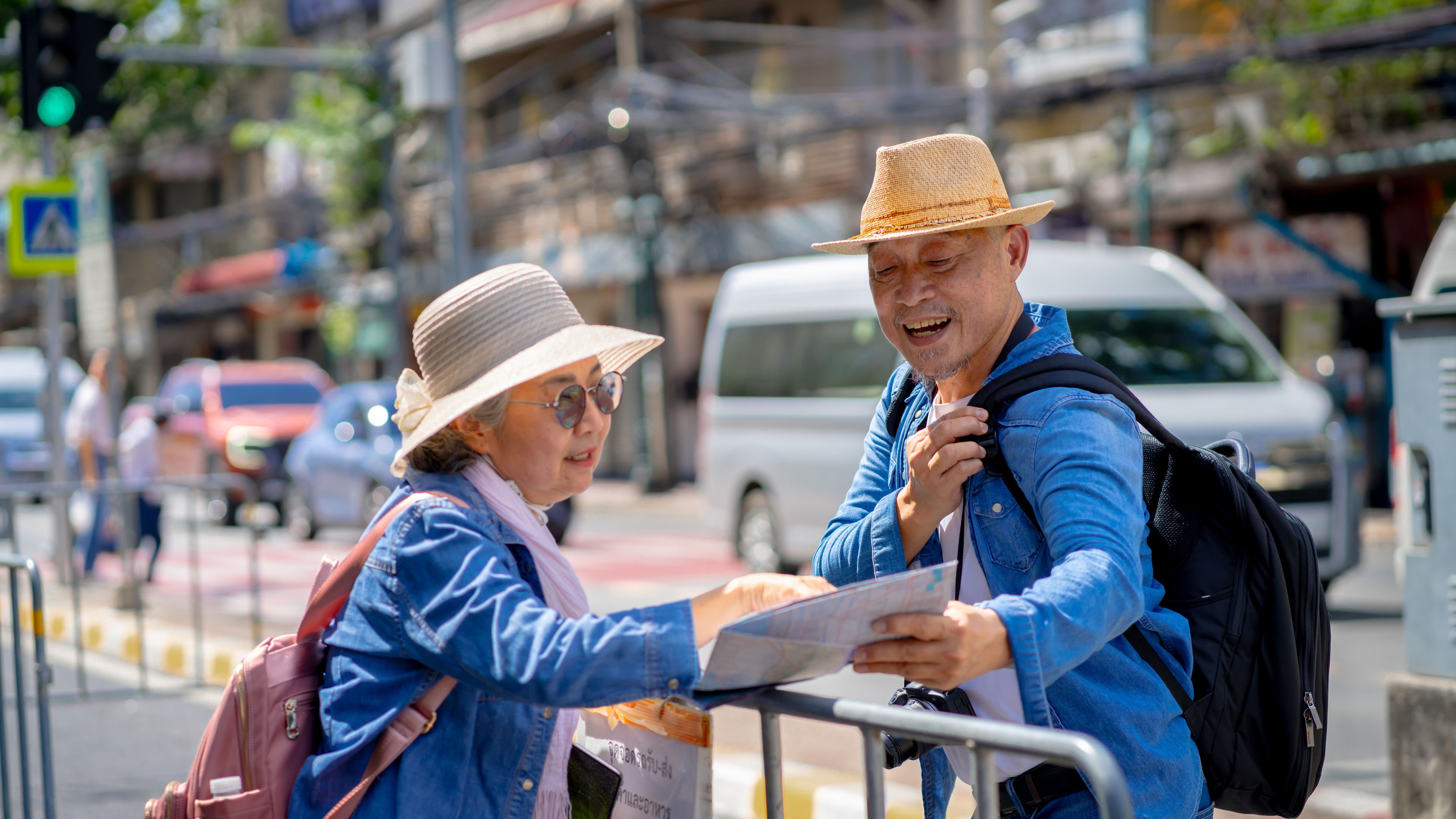 A smiling retired couple is checking a paper map