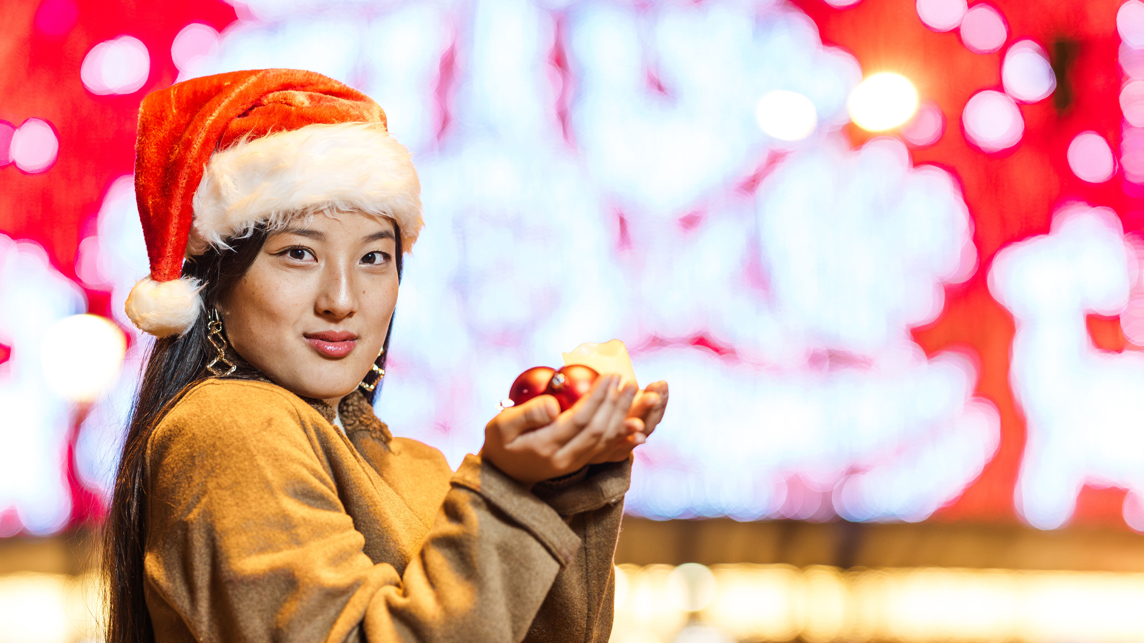 A woman holding some Christmas tree decorations