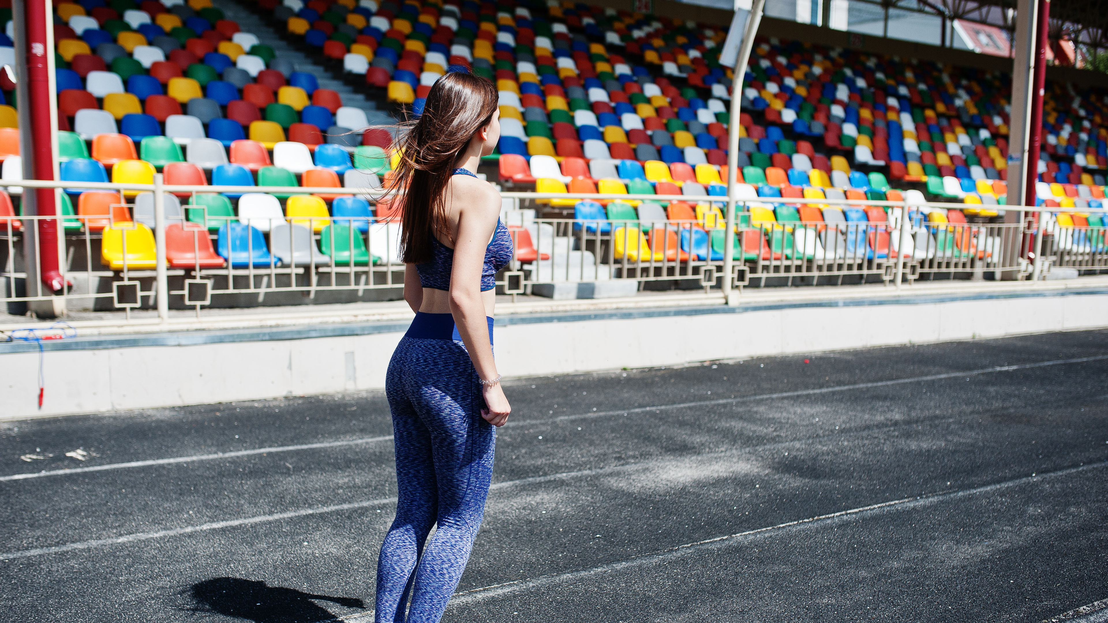 A woman is standing on a running track
