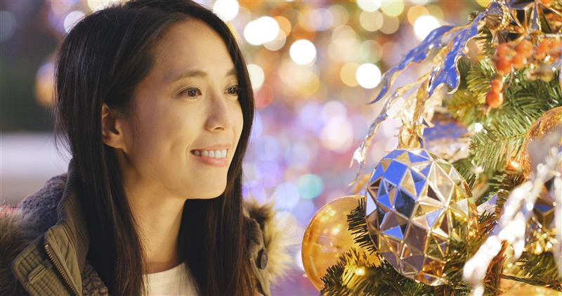 A woman looking at a Christmas tree