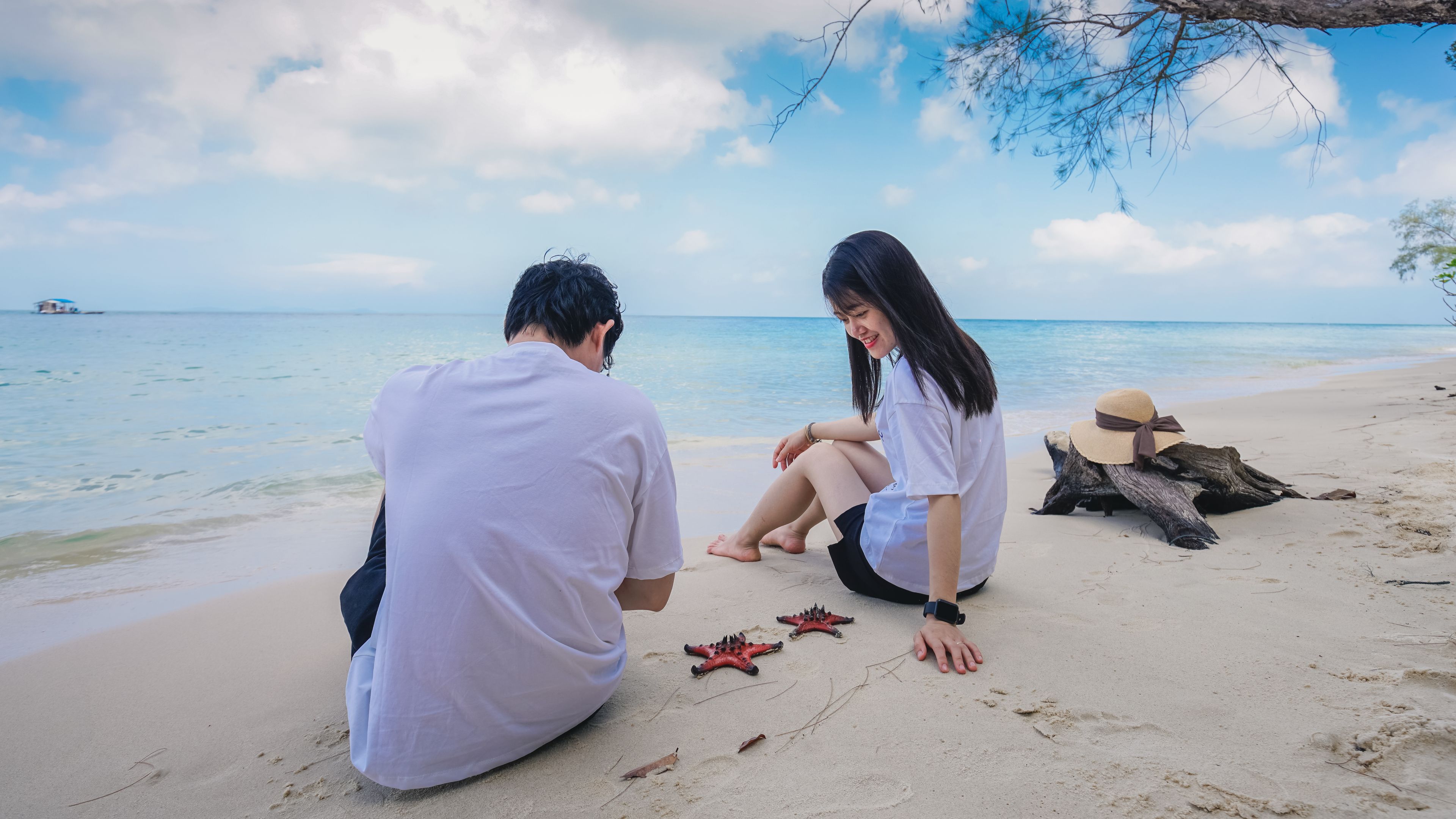 A young couple is sitting quietly on a sandy beach
