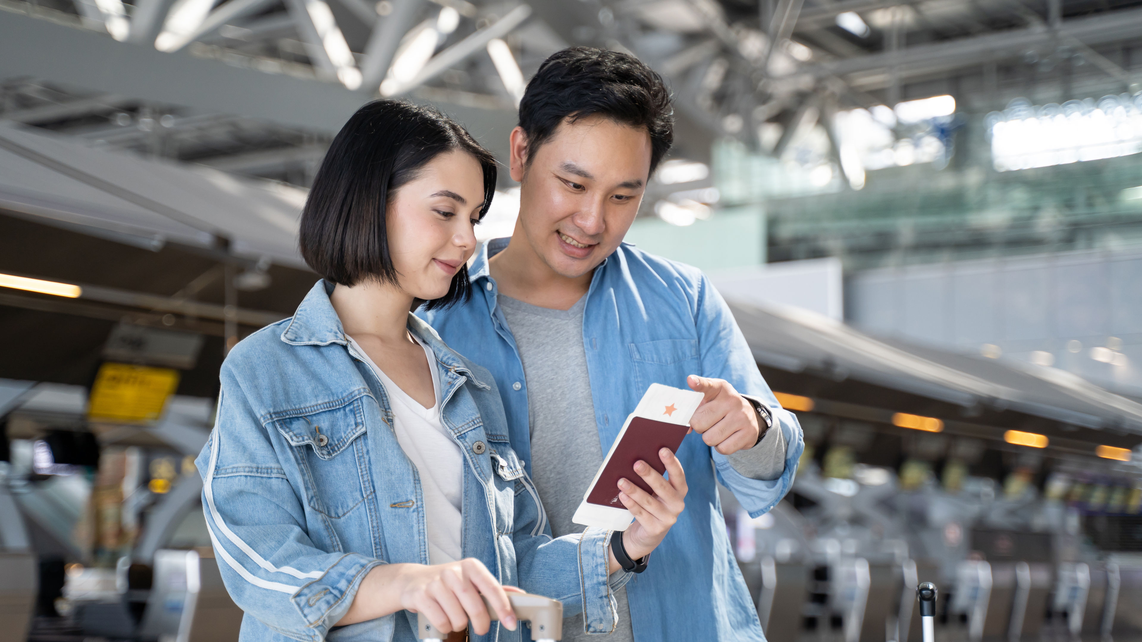 A young couple stands together at an airport
