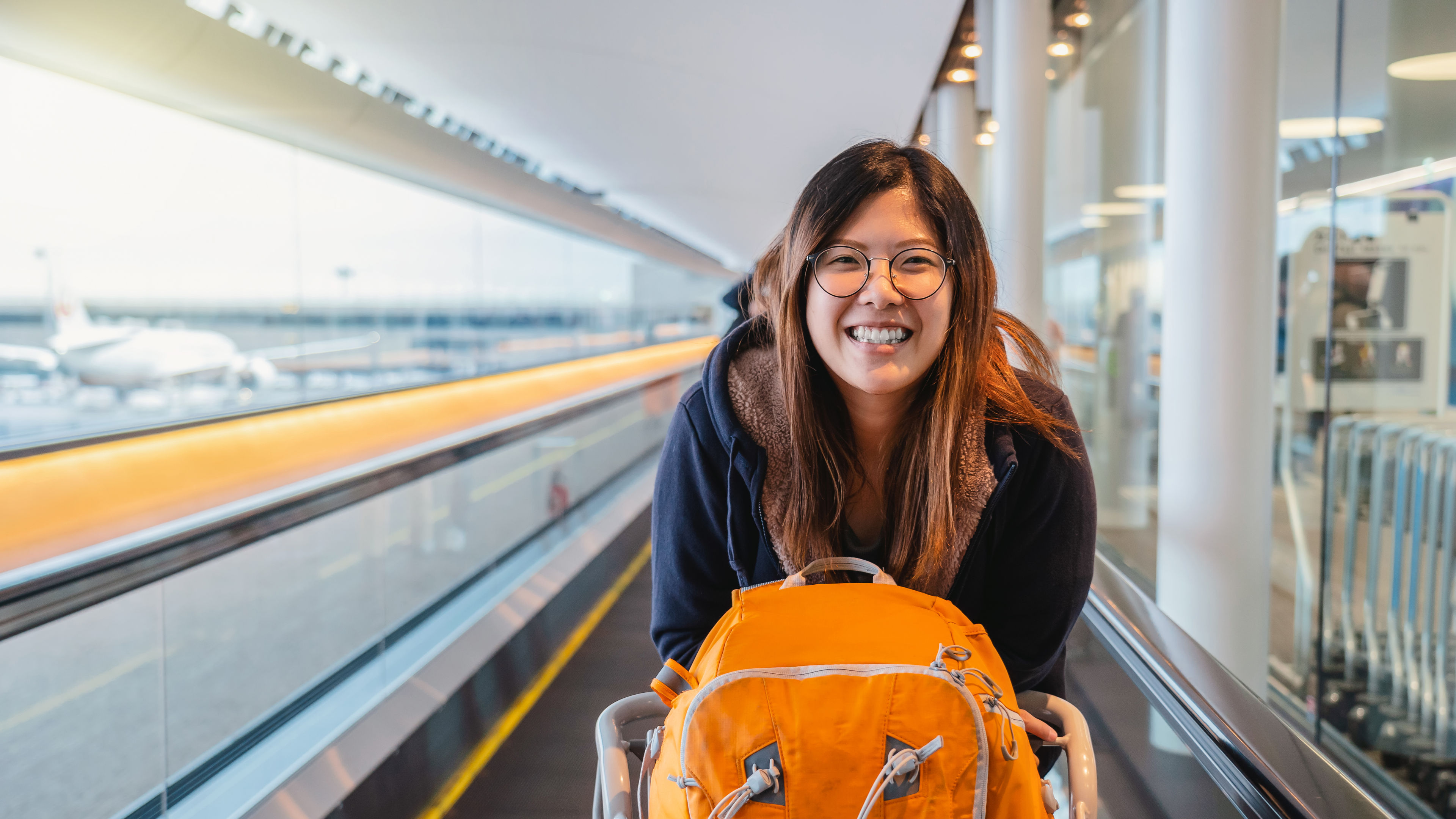 A young woman standing on a moving walkway