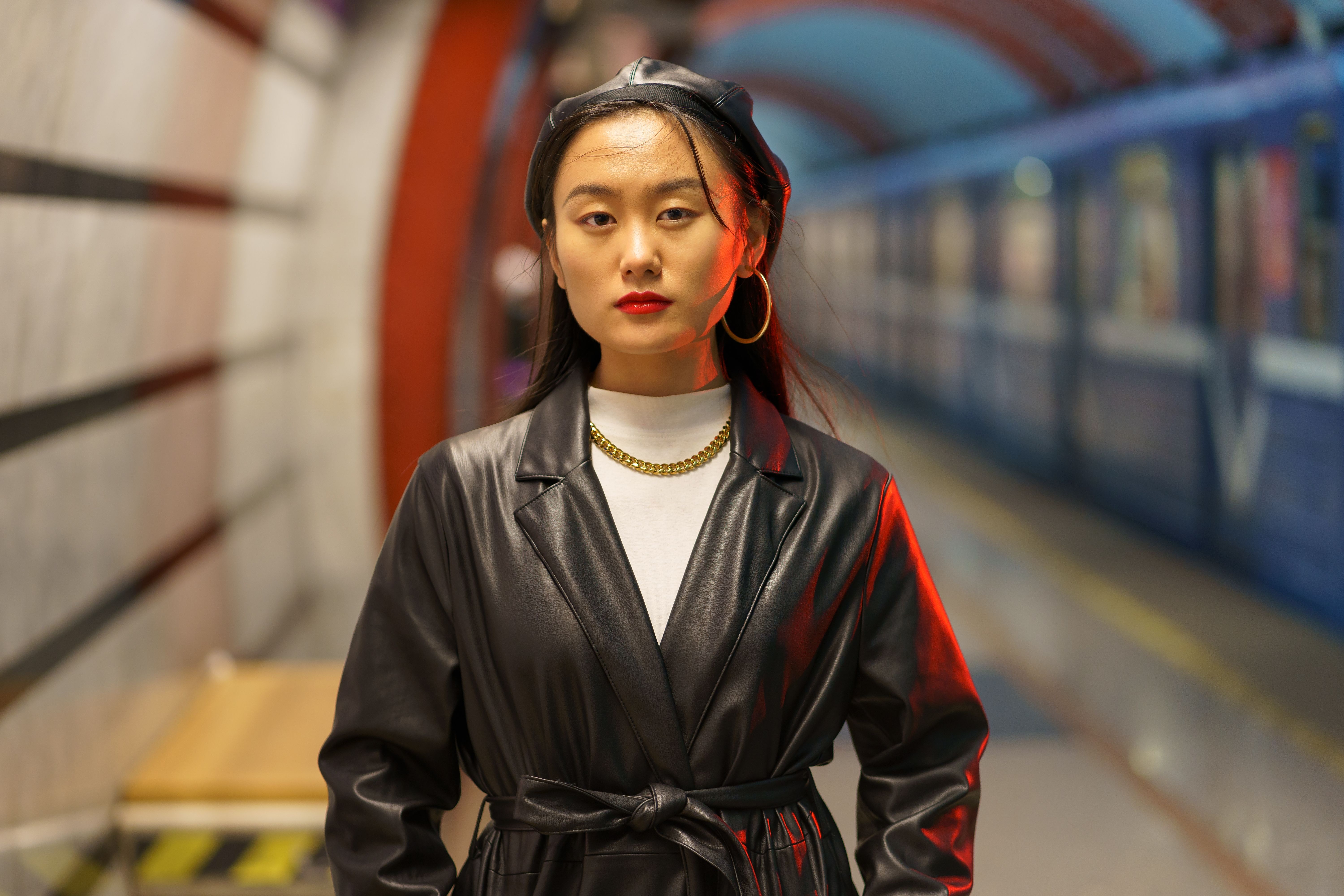 Stylish Asian girl in a leather beret and trench coat. 