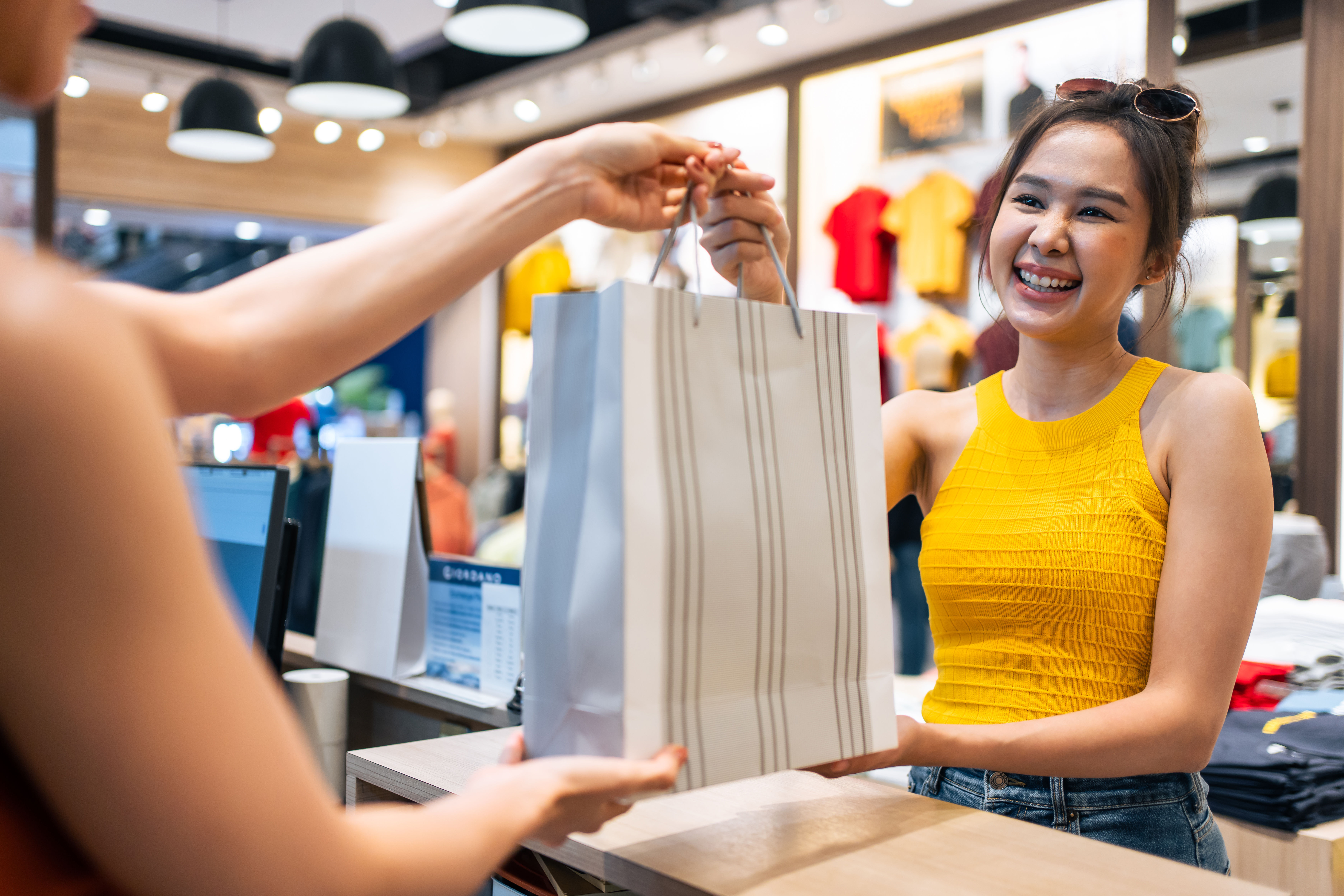 Image of an asian woman in yellow dress purchasing clothes 
