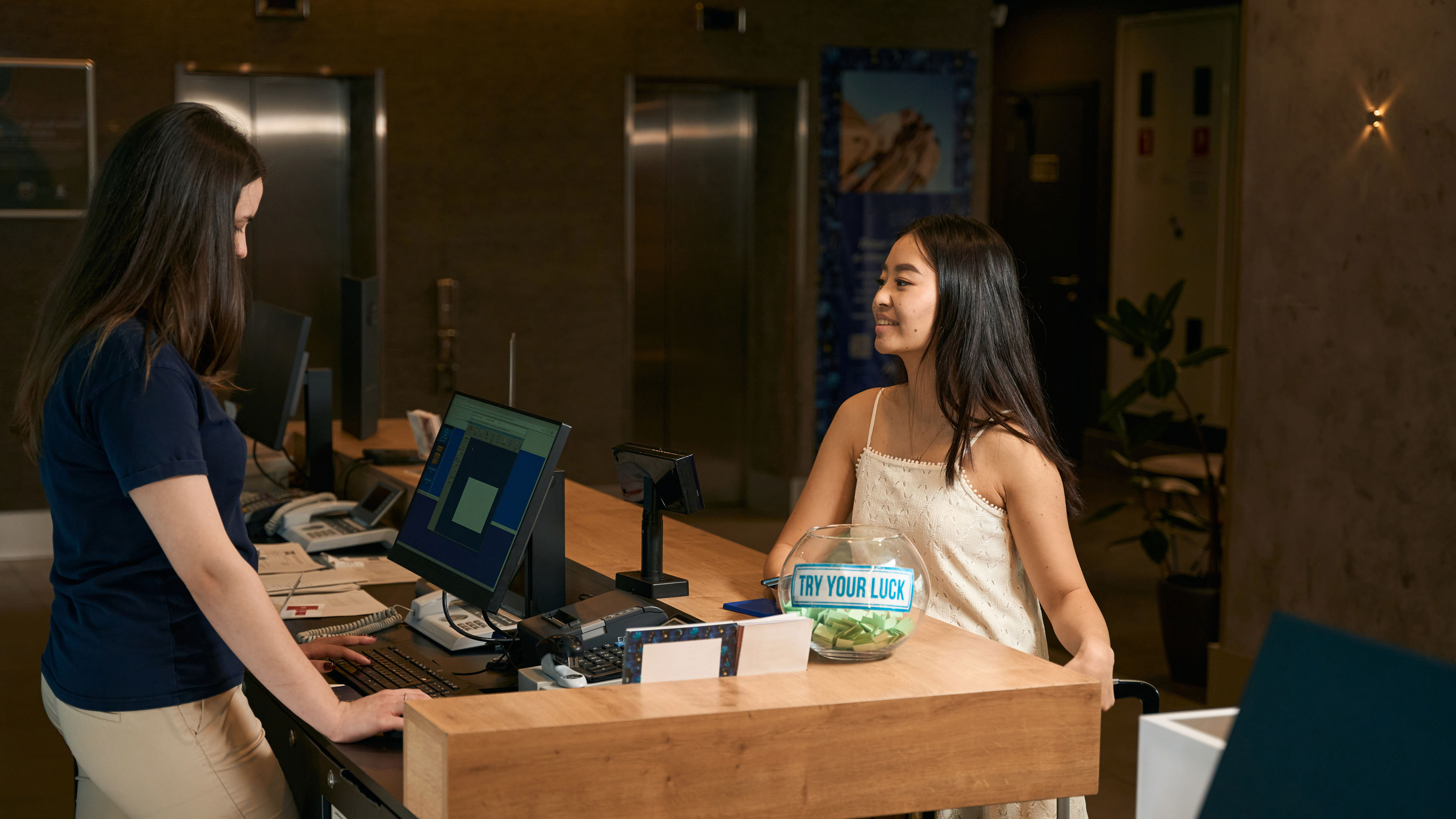 Asian woman talking to the hotel manager at the reception