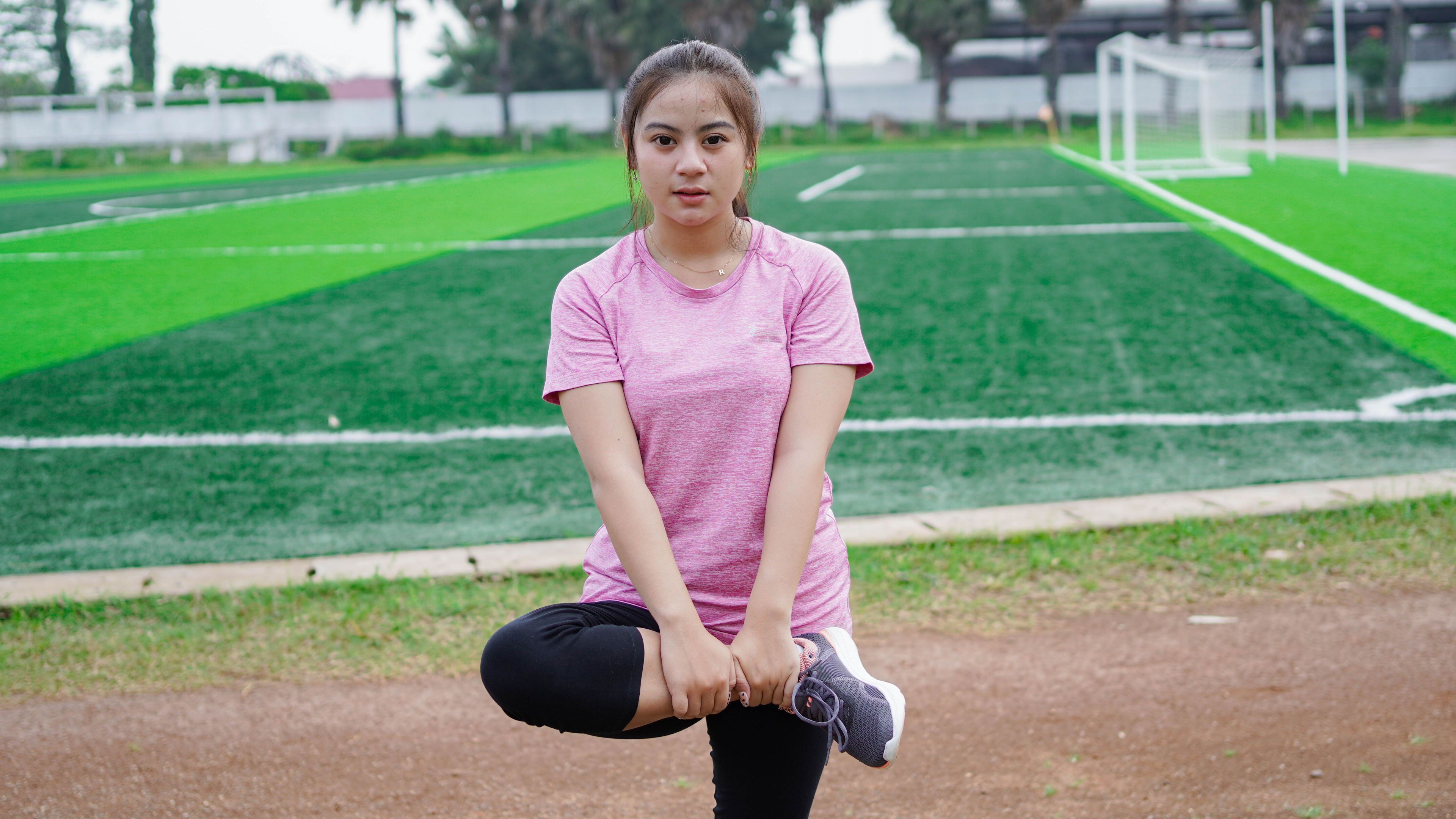 asian woman warming up before running 