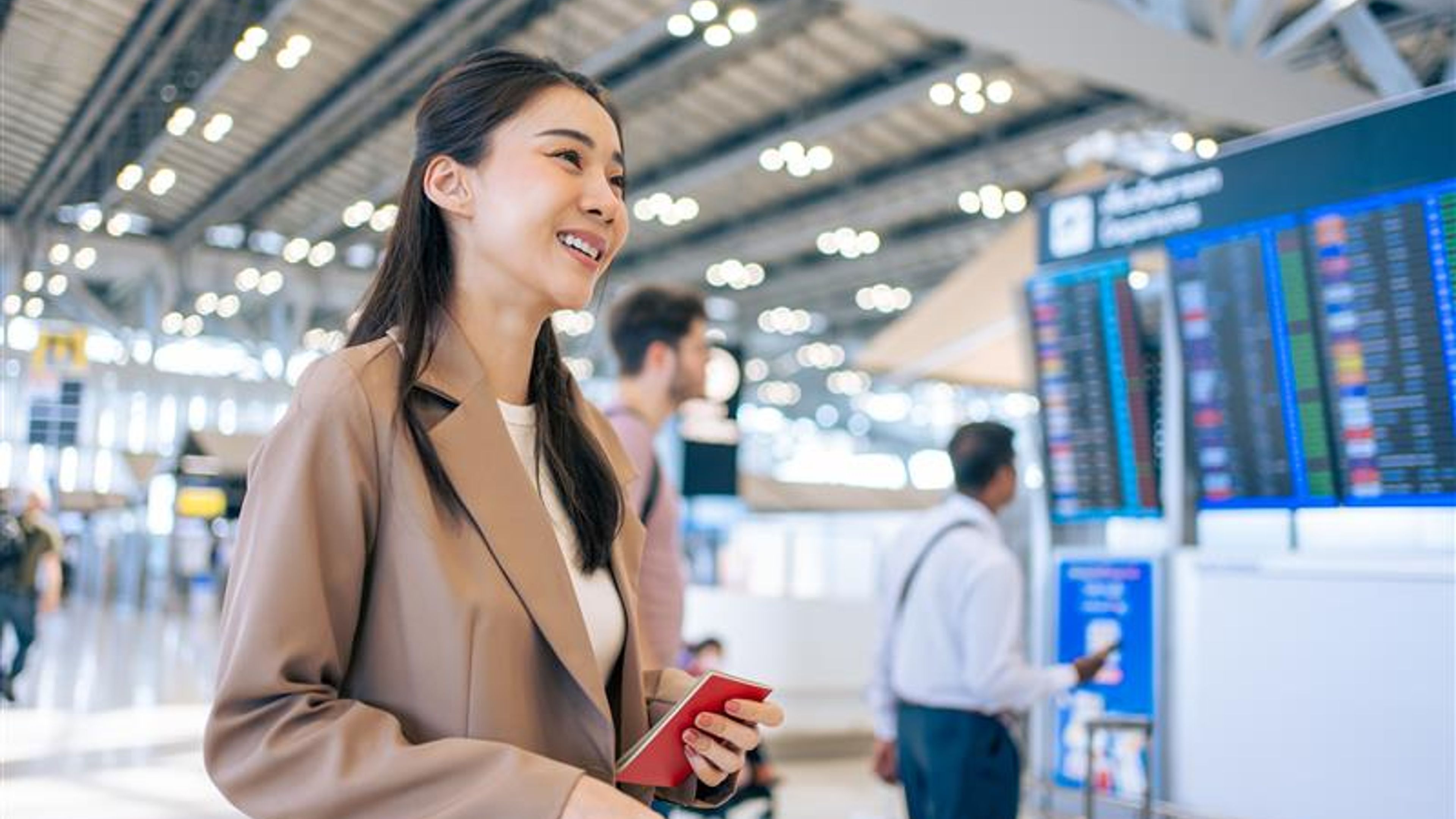 Asian young woman passenger checking depature boarding pass in airport. 