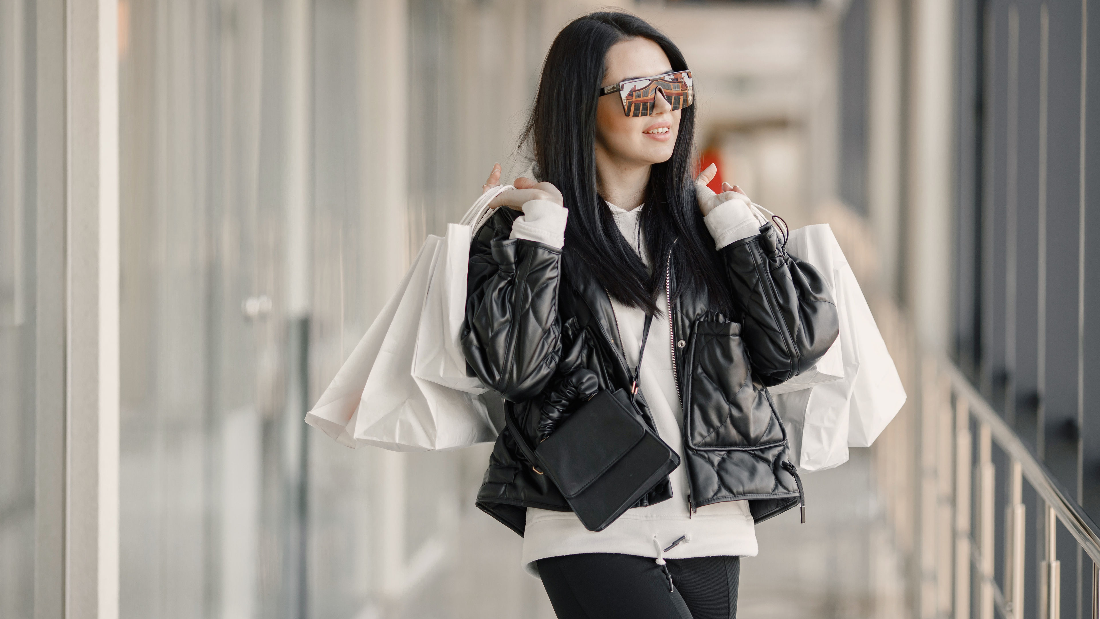 Brunette woman carrying shopping bags with a cheerful smile 