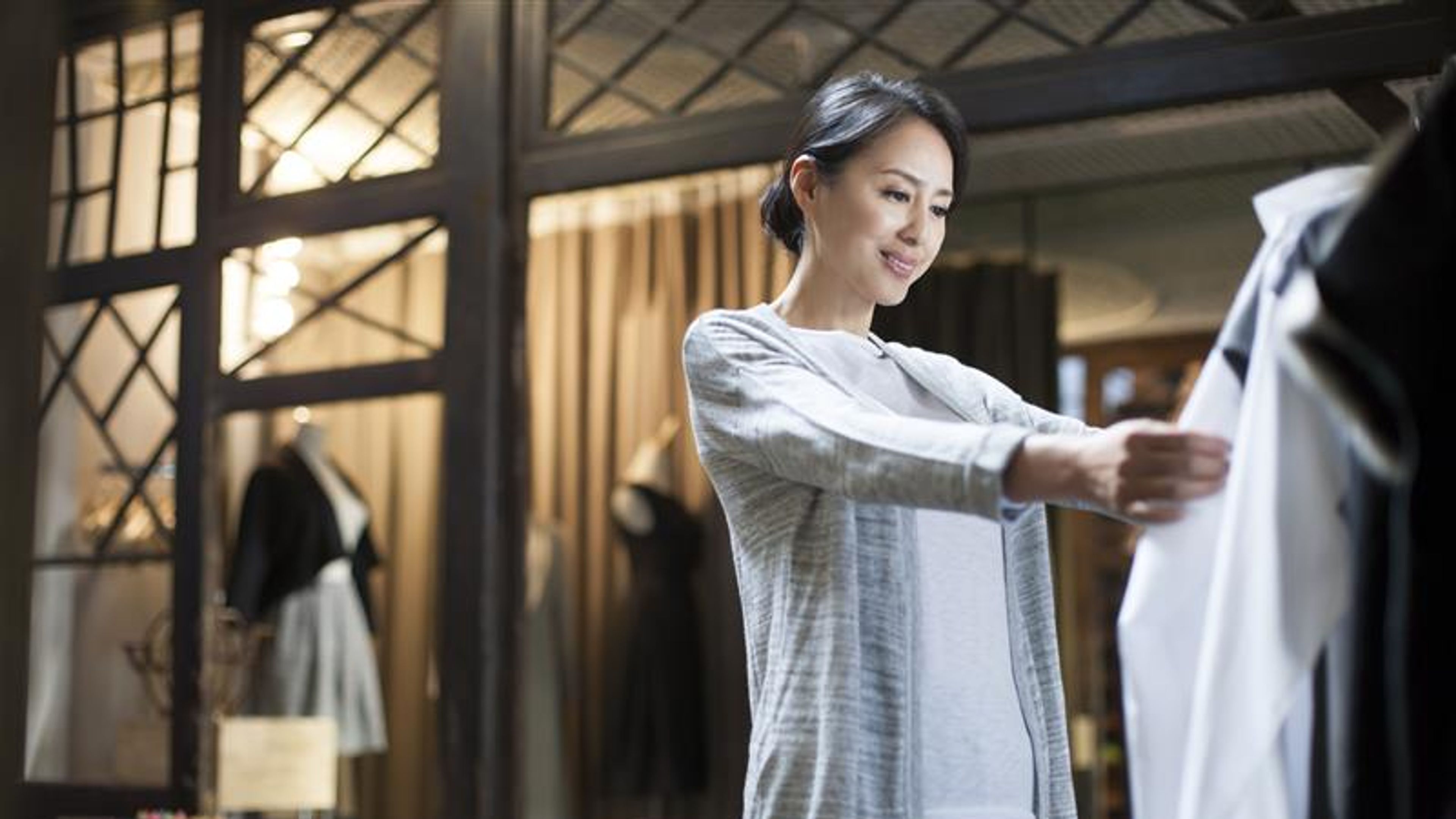 Chinese clothing store owner checking clothes 