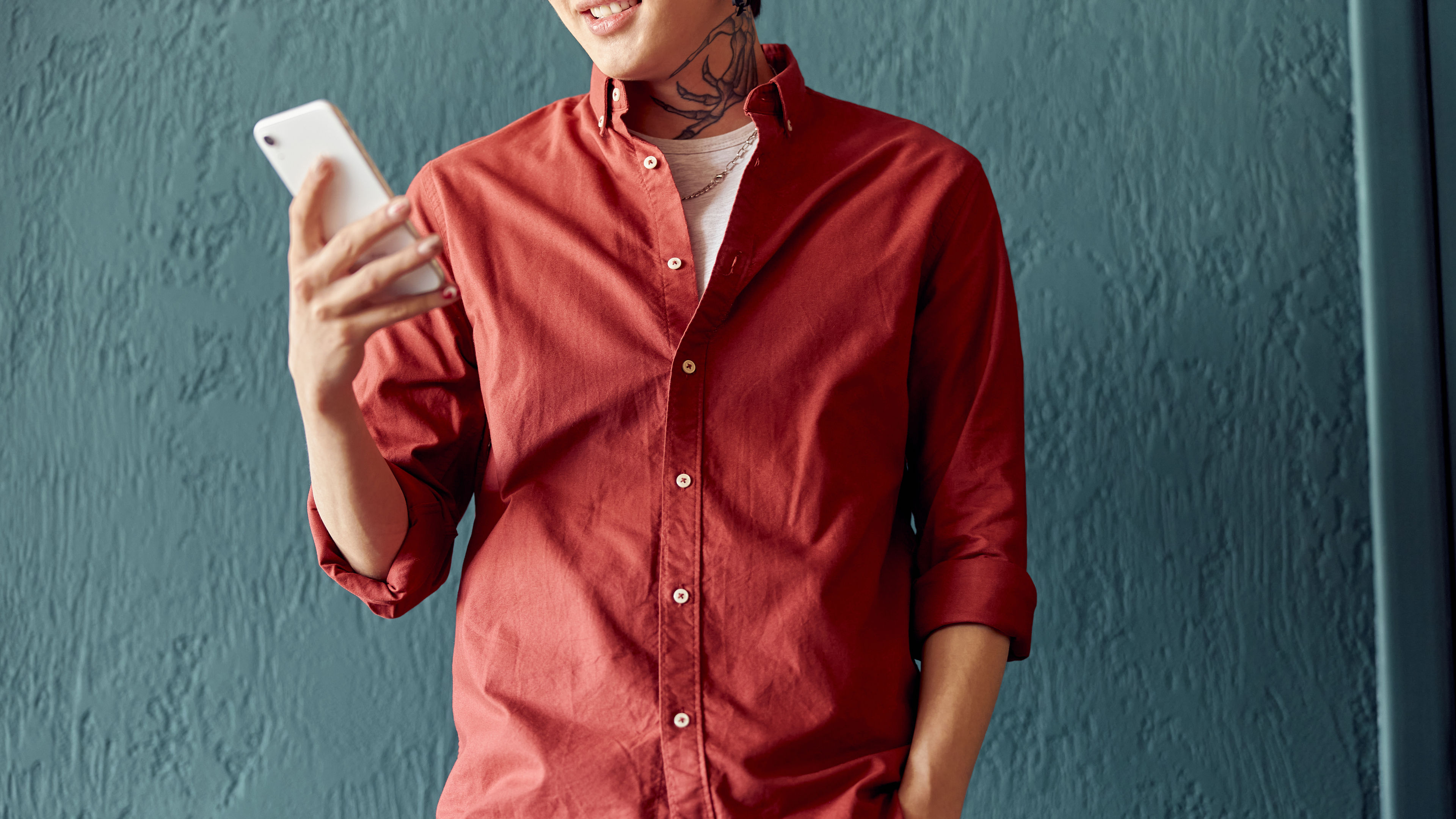 Cropped photo of smiling young man using mobile phone while reading the message