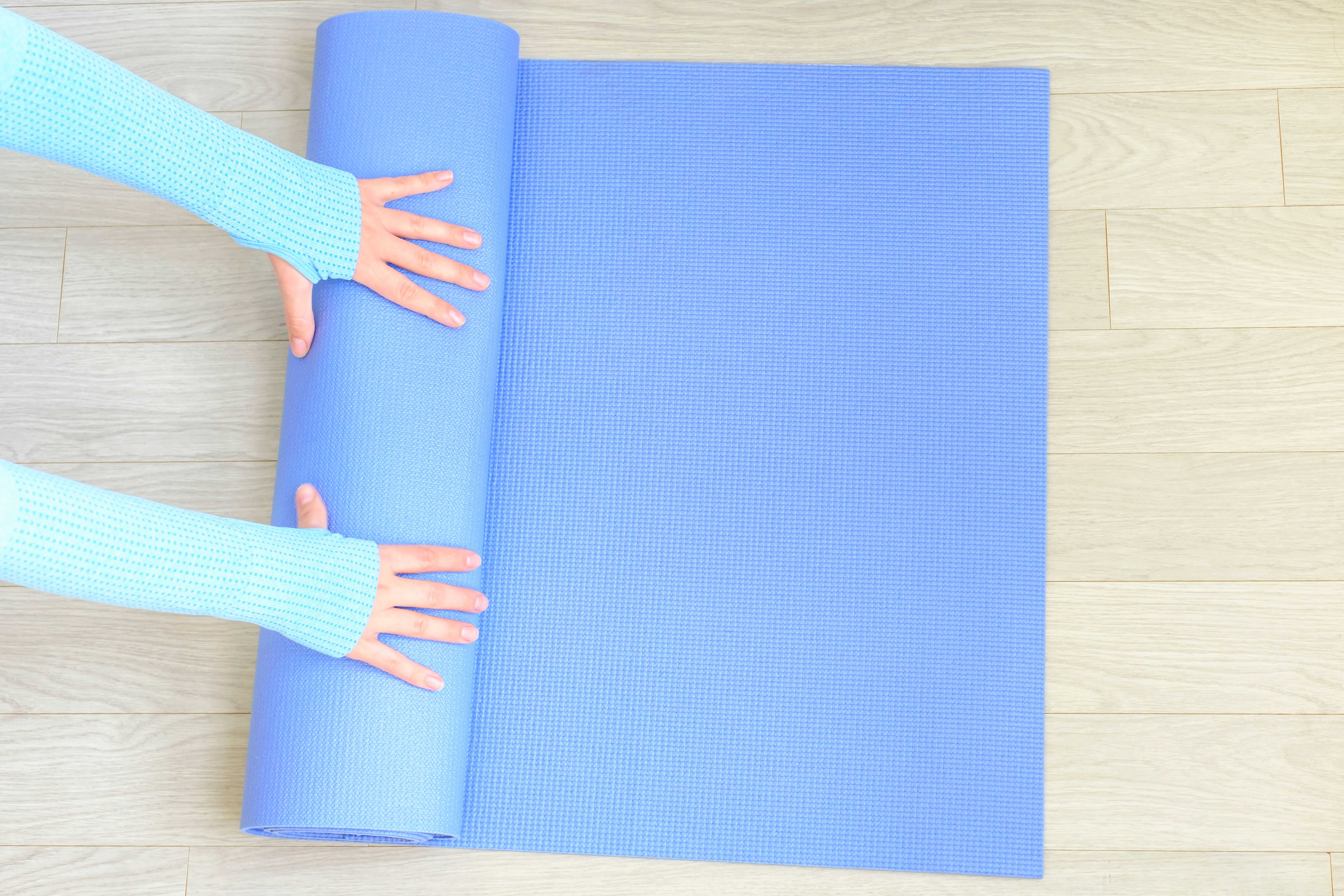 Image of female hands rolling a mat 