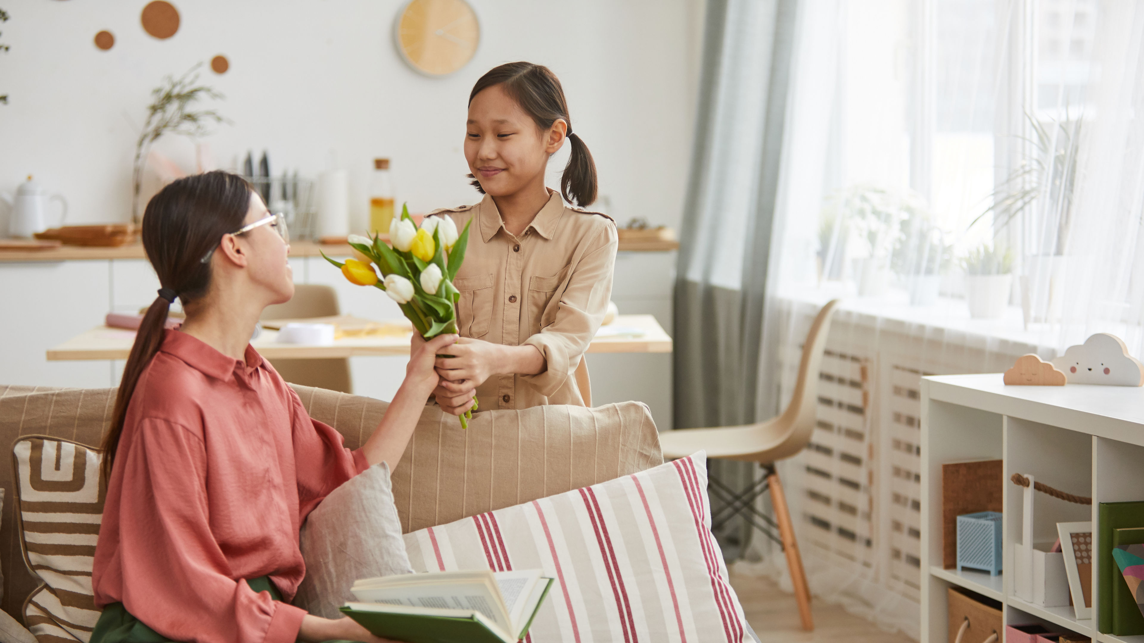 Girl giving bunch of flowers to her mom