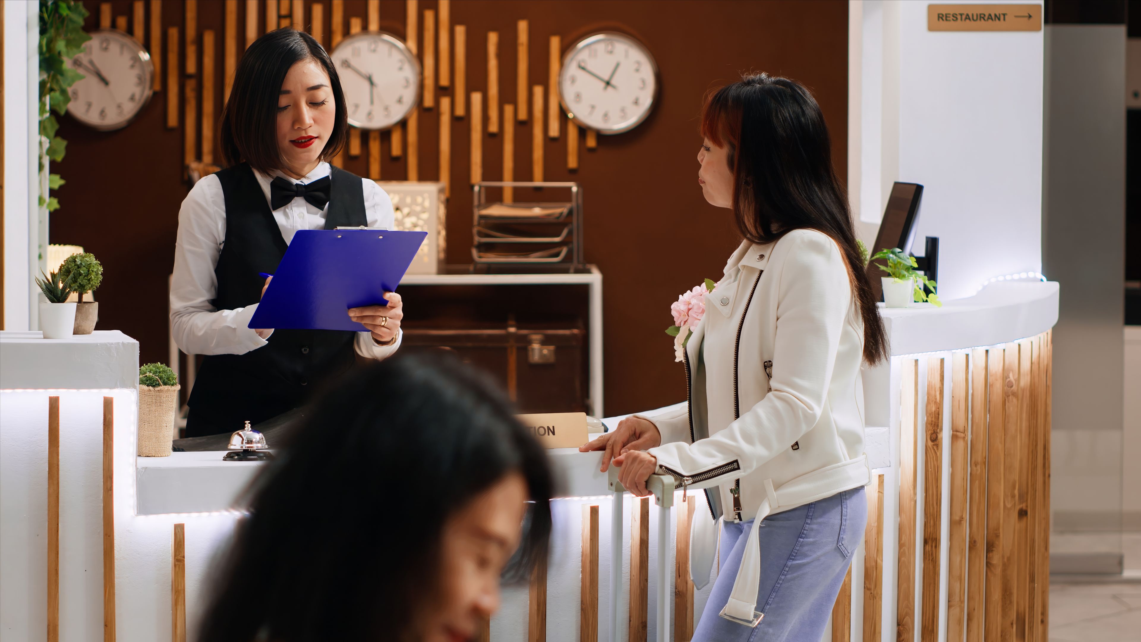 Hotel guest signing registration papers at front desk