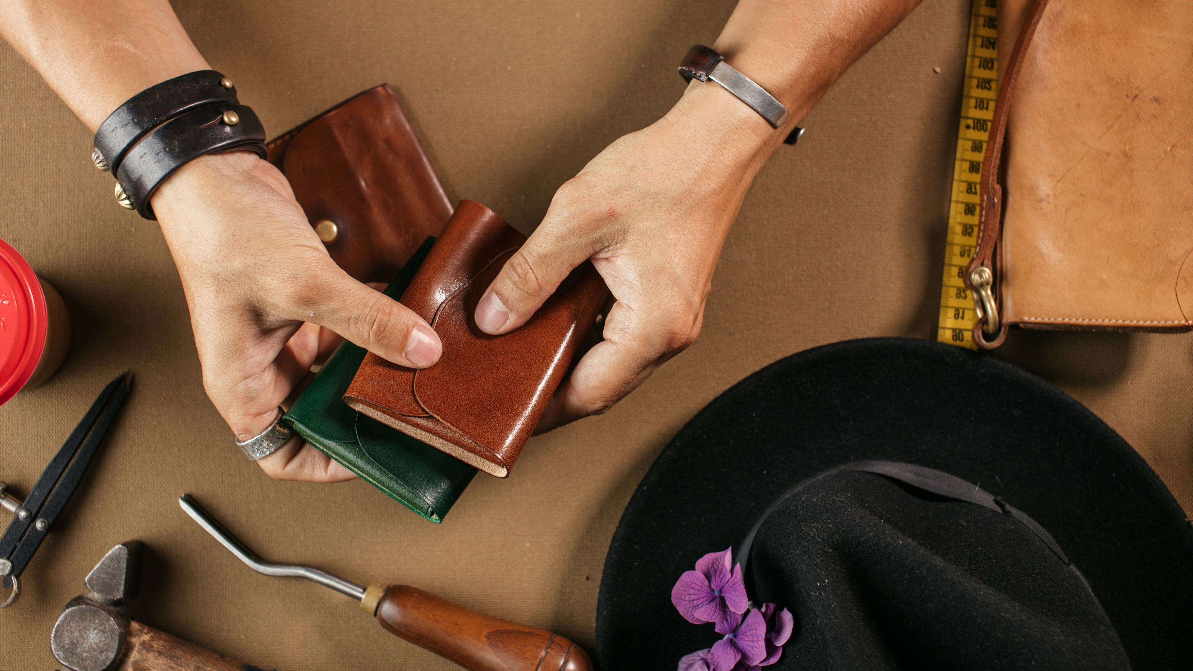 Leather goods master and handmade leather wallets. Workflow in the workshop