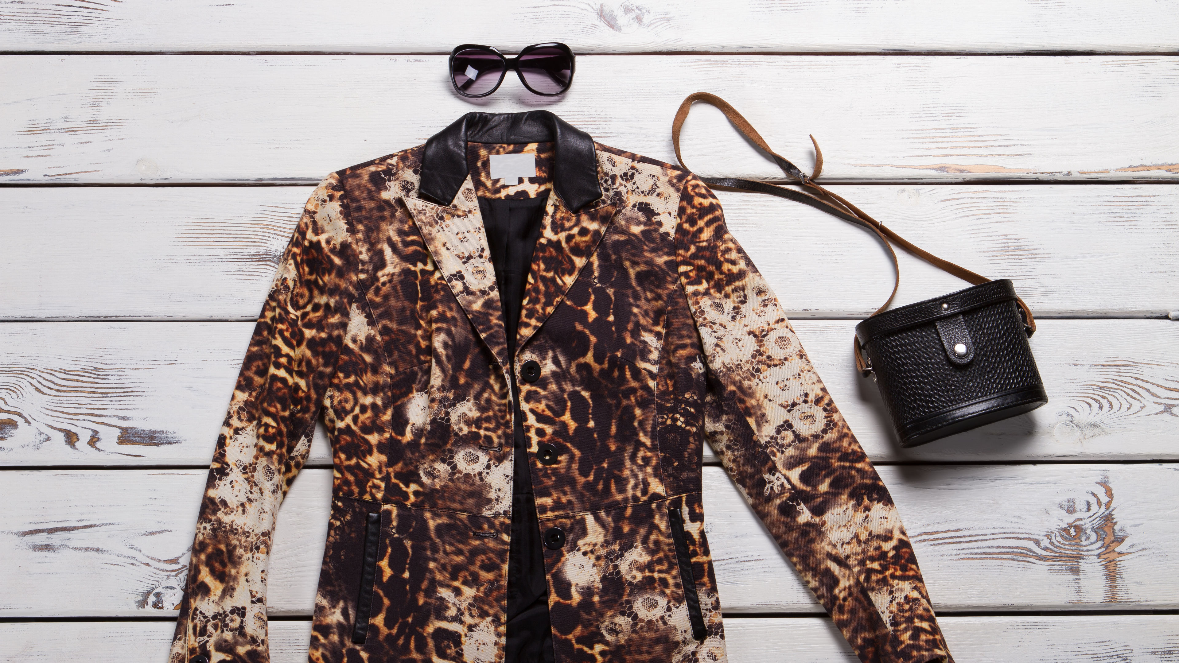 Leopard Blazer And Black Purse. Sunglasses And a Vintage Bag. Luxury Clothing Item On Display