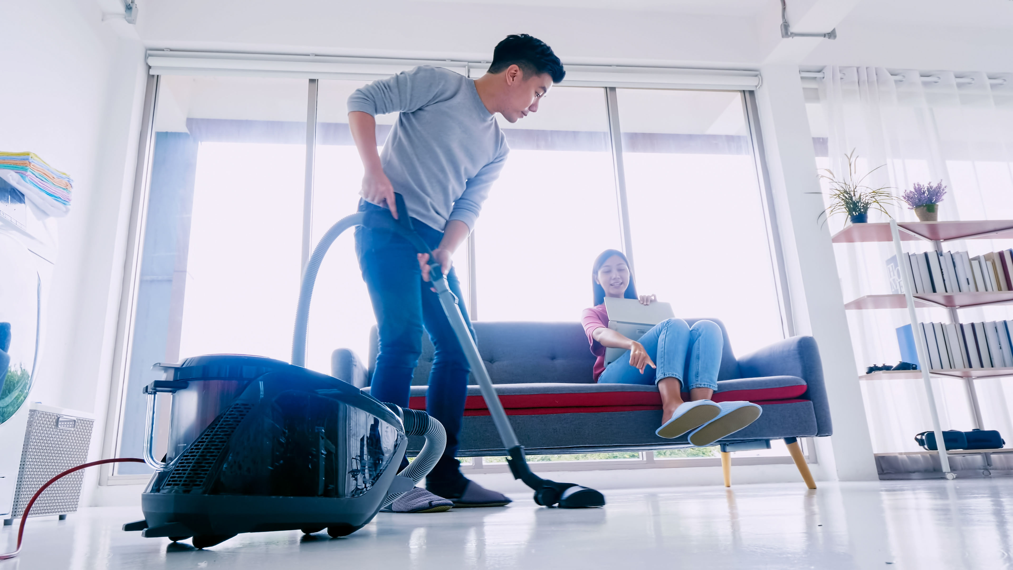 Man Cleaning the floor with vaccum cleaner
