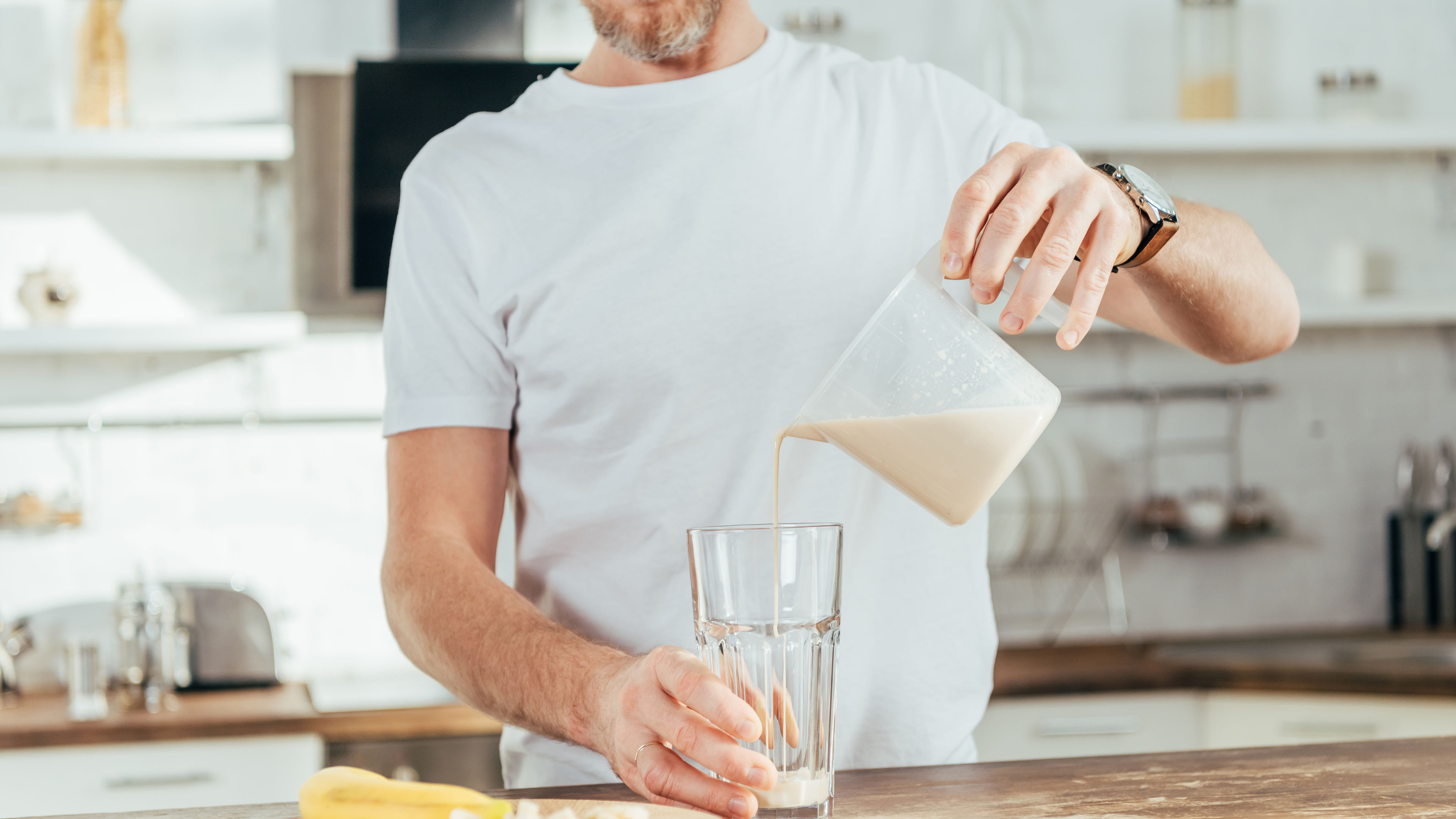 Man pouring protein shake to glass cup