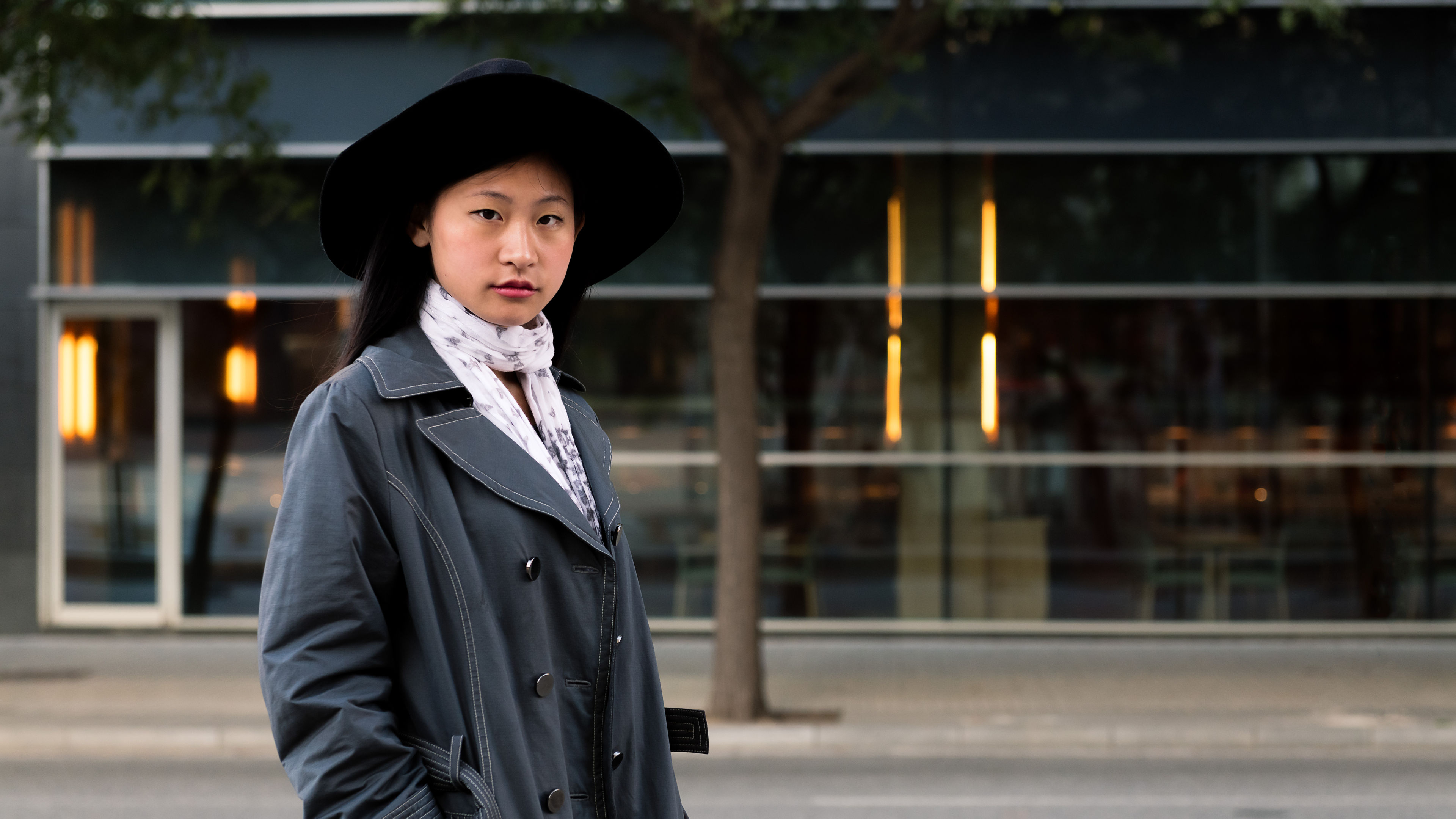 An elegant portrait of a beautiful Asian woman, gracefully styled in a chic hat and fashionable coat, radiating sophistication and charm. 