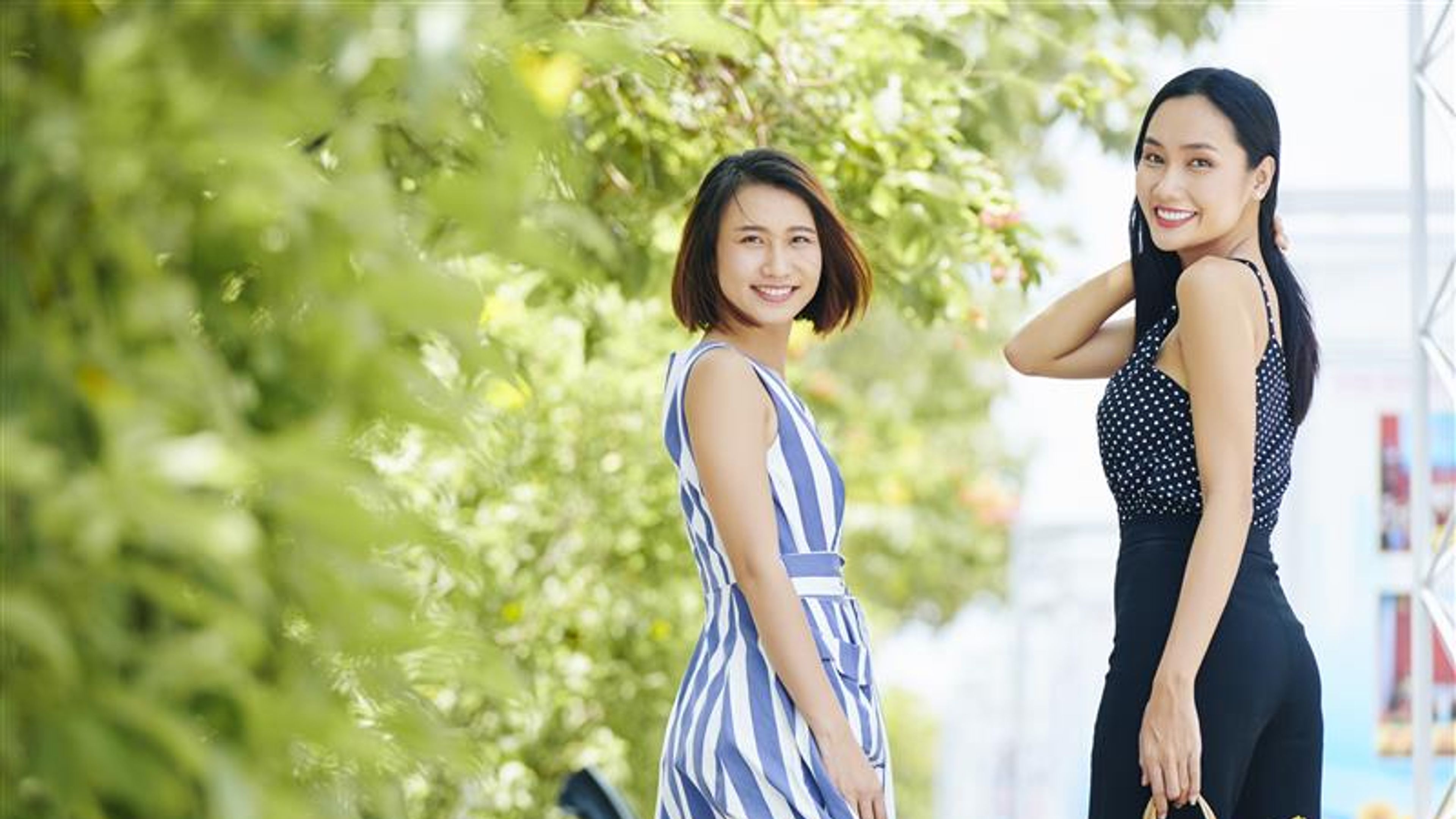Portrait of two Asian women looking very stylish smiling at camera