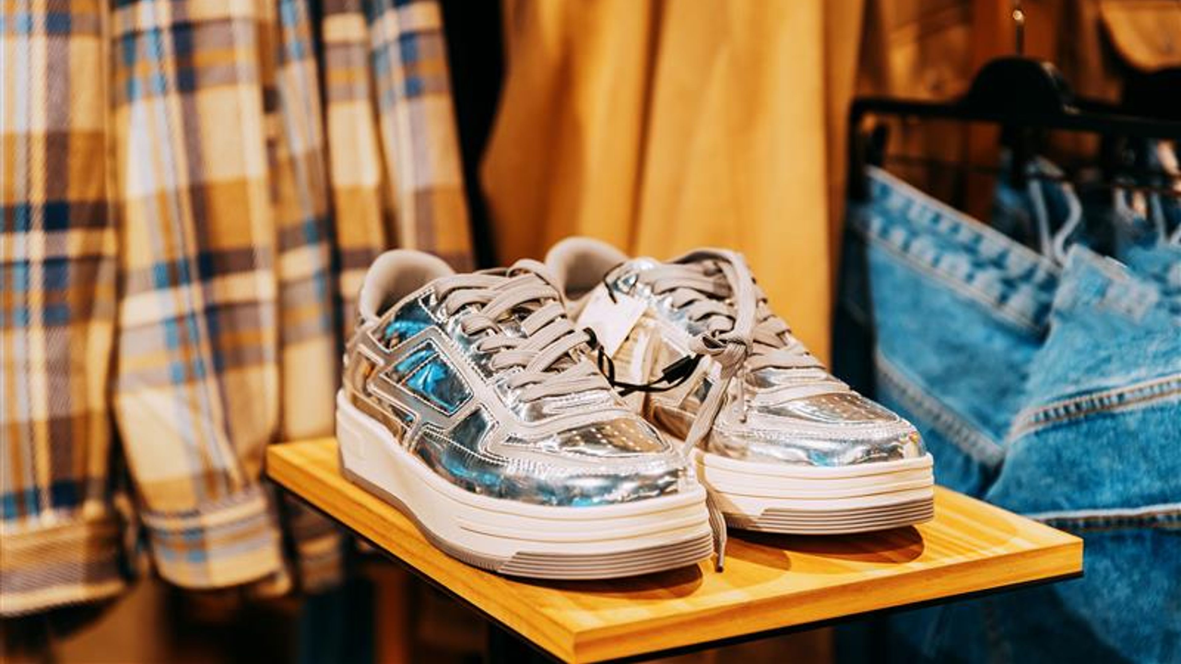 silver sneakers shoes on shelf display in shop mall store