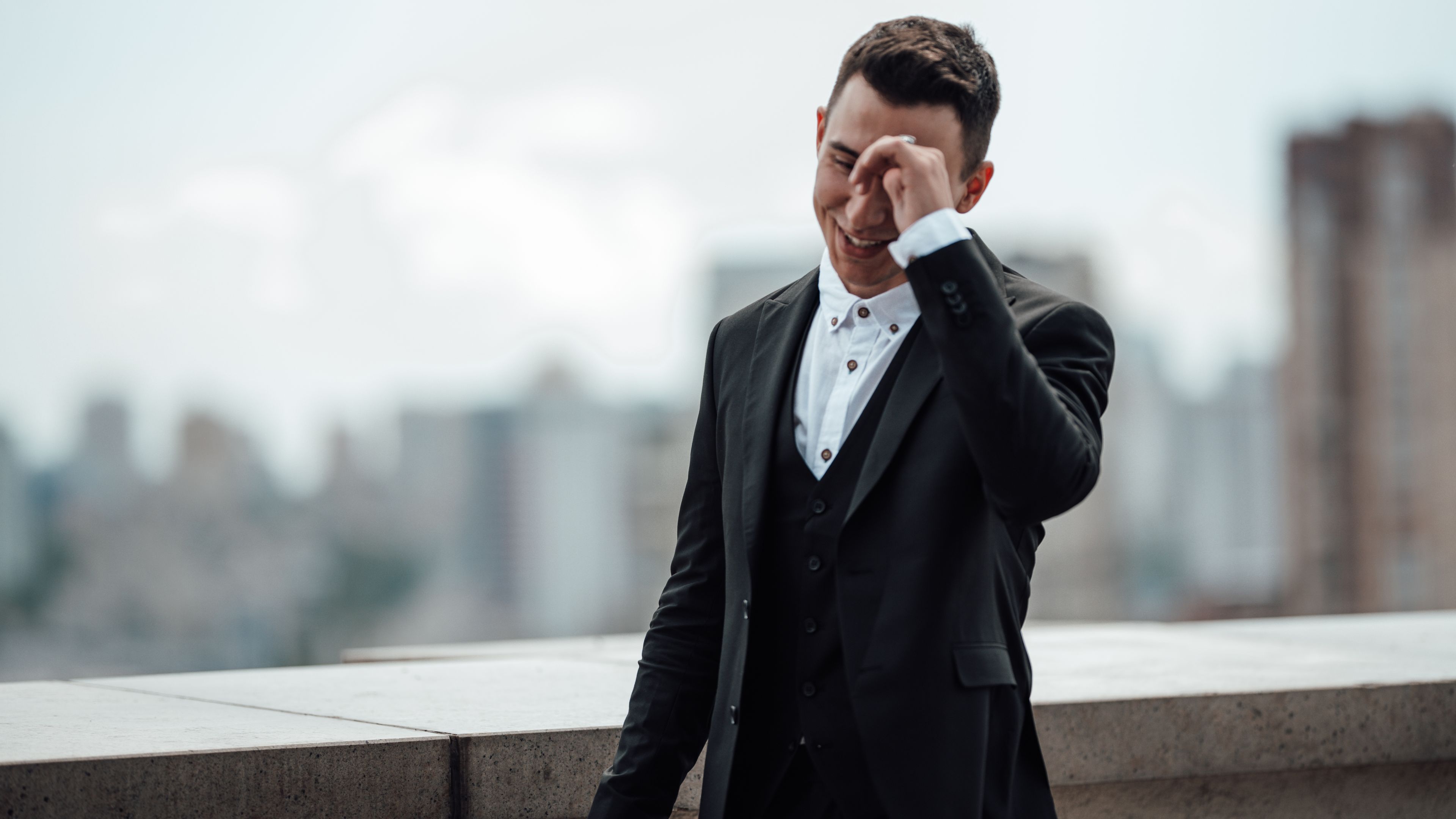 Stylish lovely fiance in formal evening wear is going to wedding ceremony outdoor wearing black suit