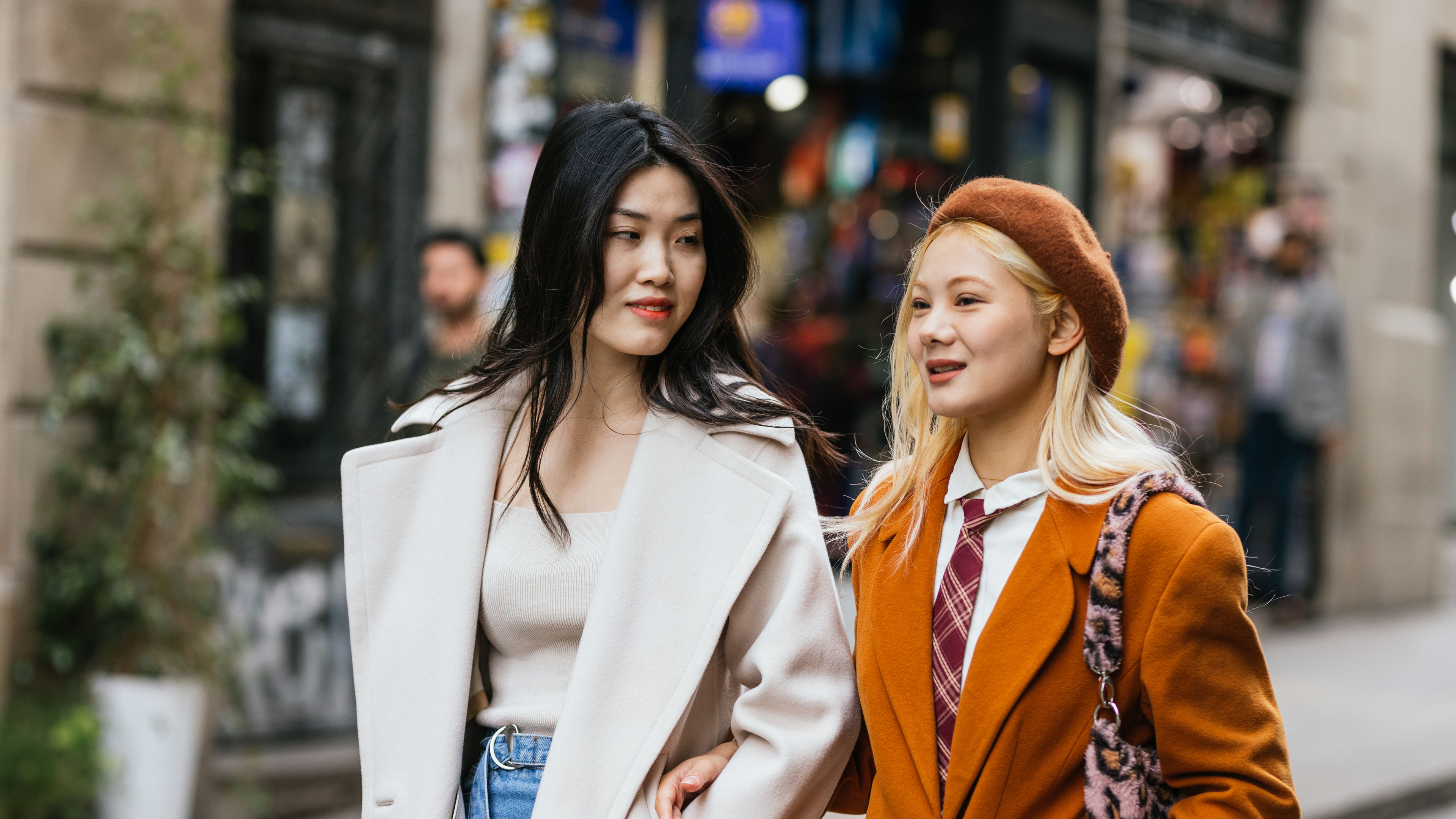 兩個时髦嘅年輕女子一起走喺街上。 