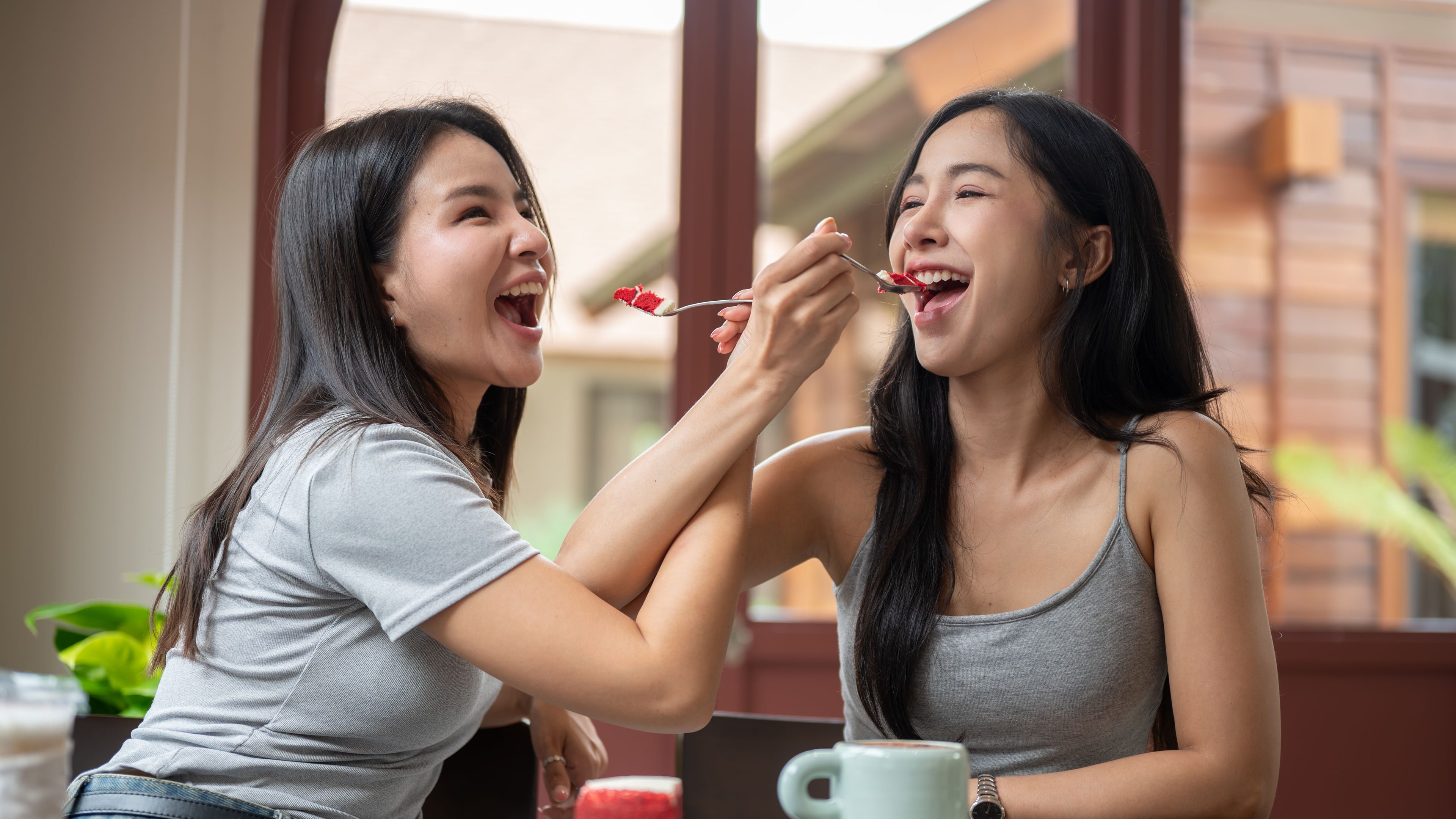 Two women tasting desserts