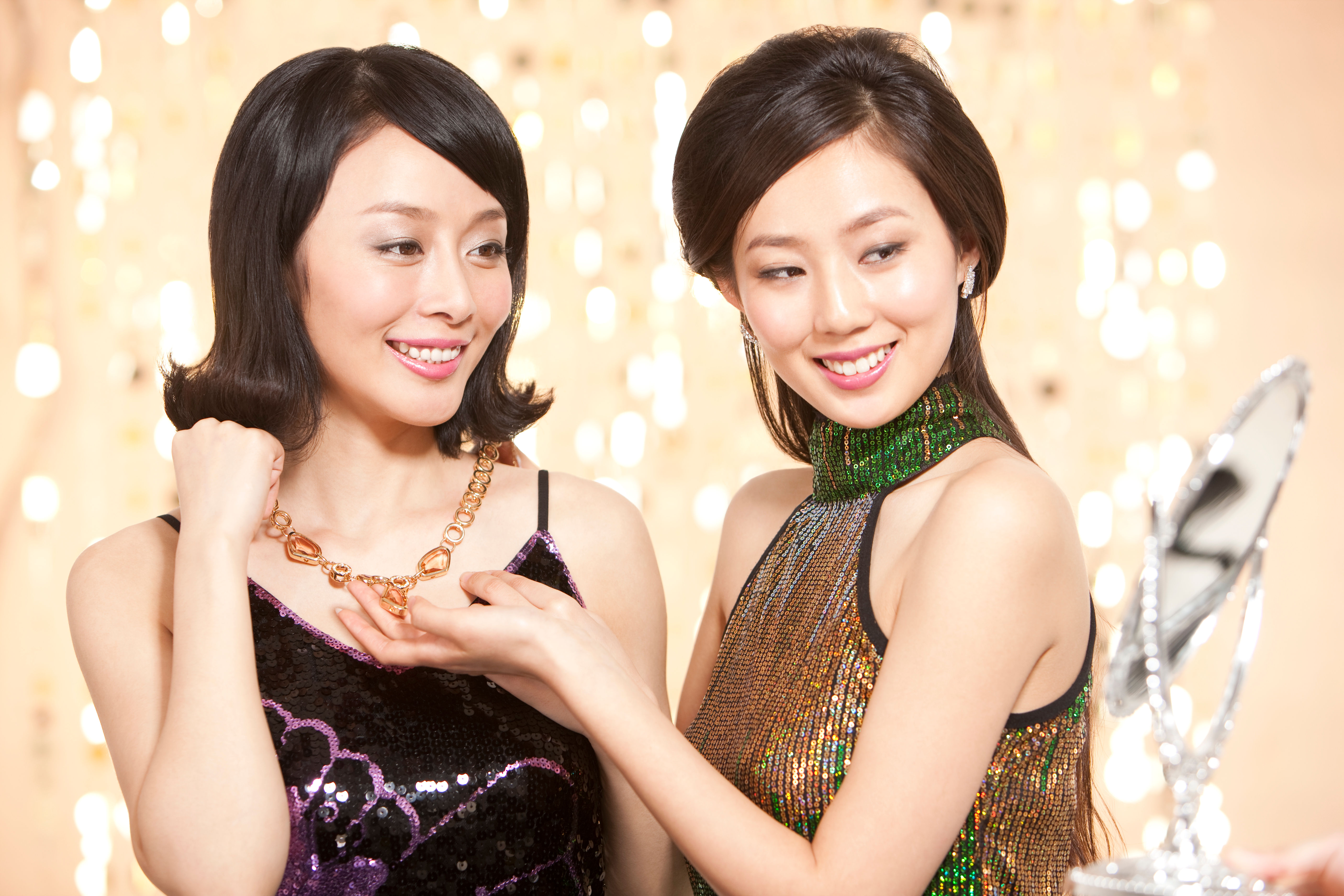 Two women trying pieces of jewelry 