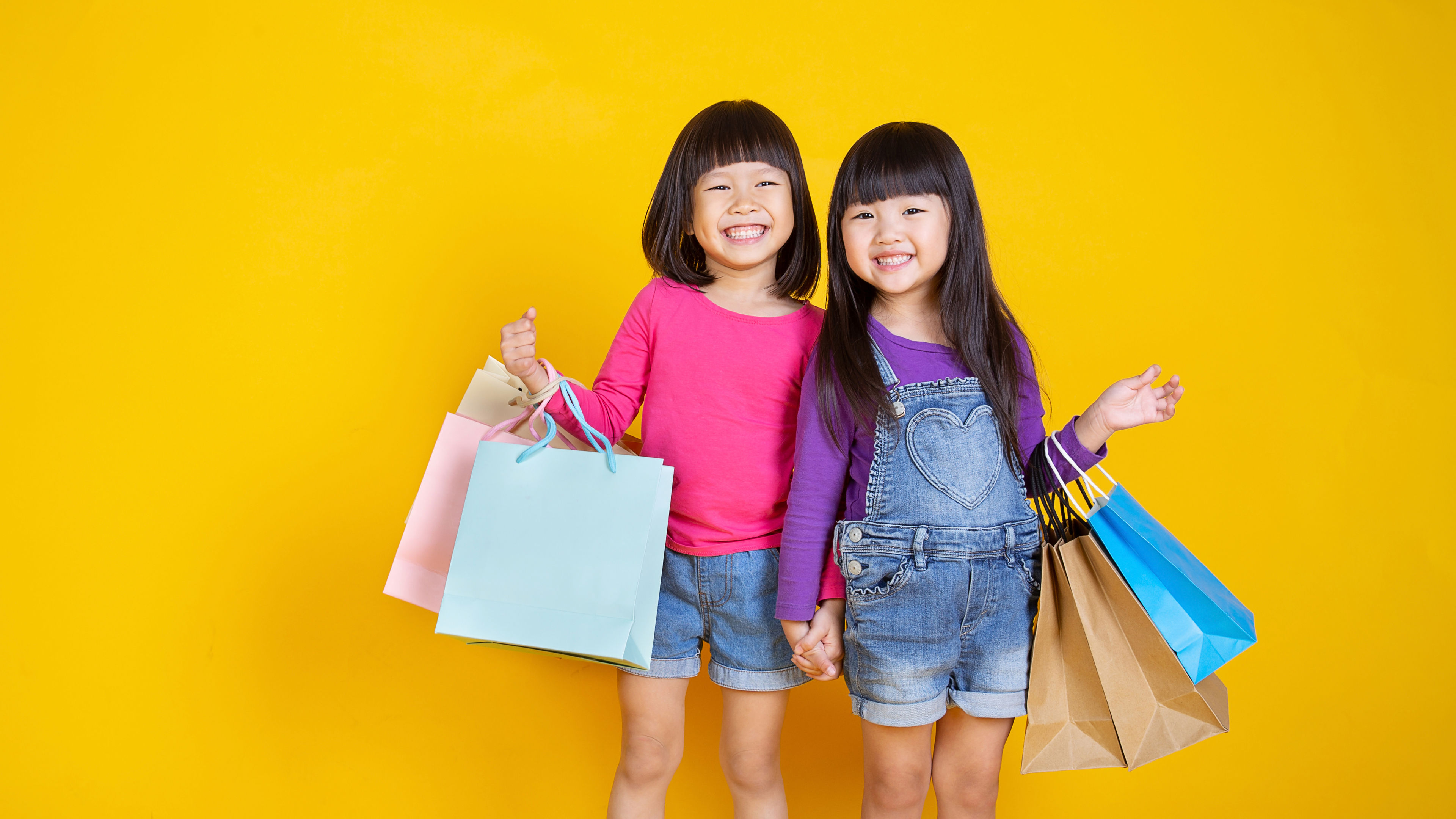 Two Young Girls Holding Shopping Bags
