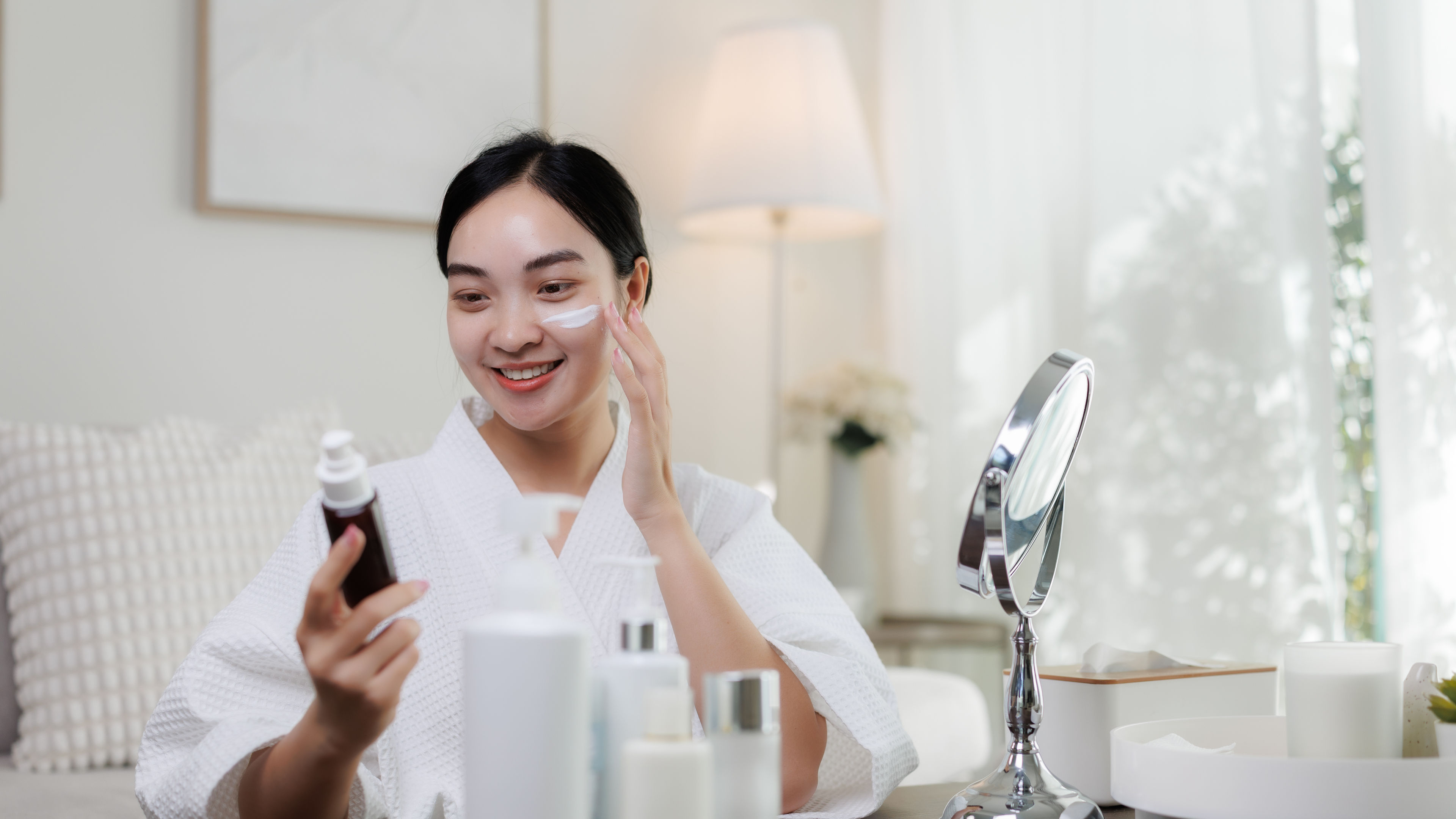 Woman applying moisturiser