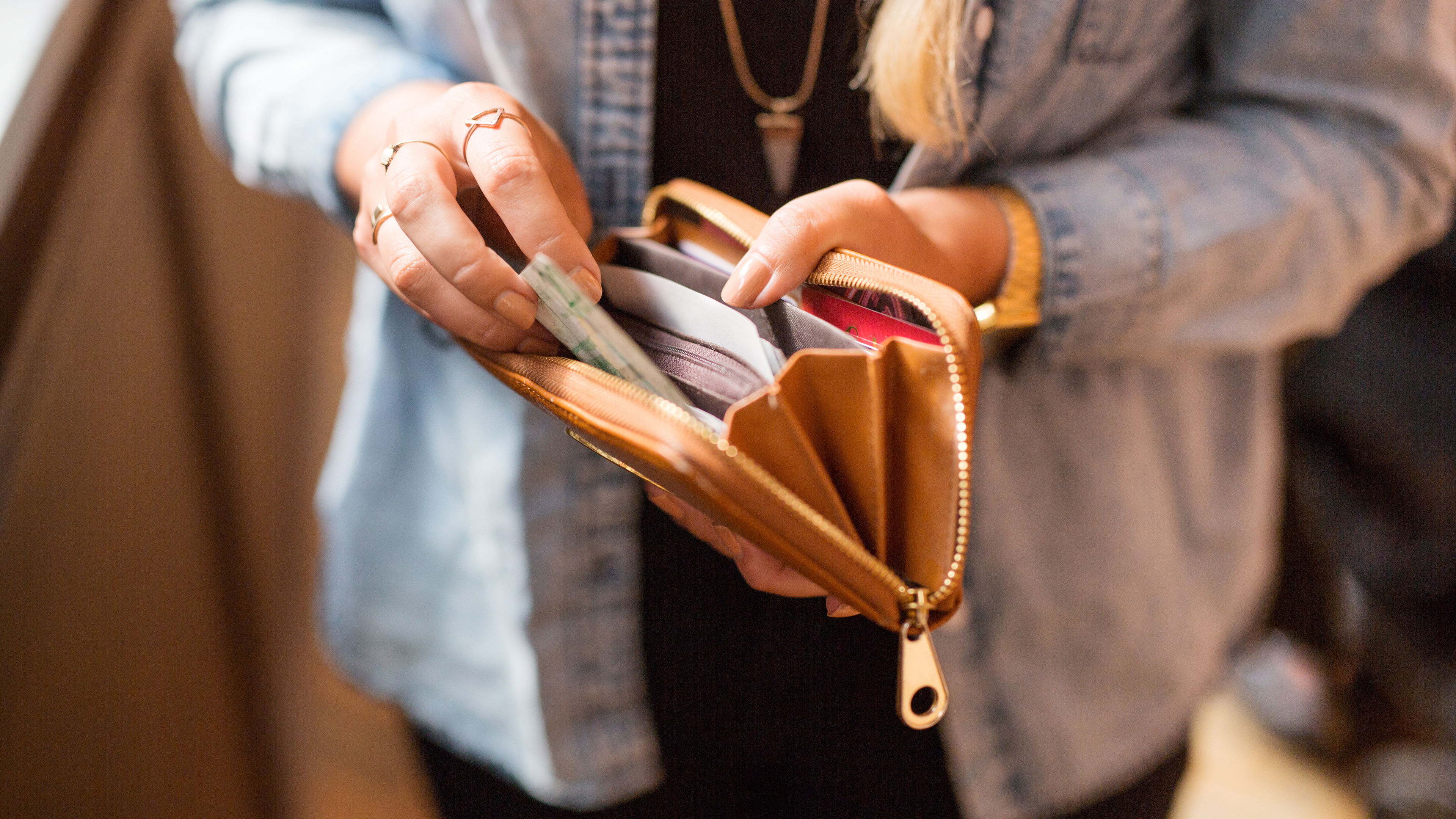 Woman holding open wallet and banknote