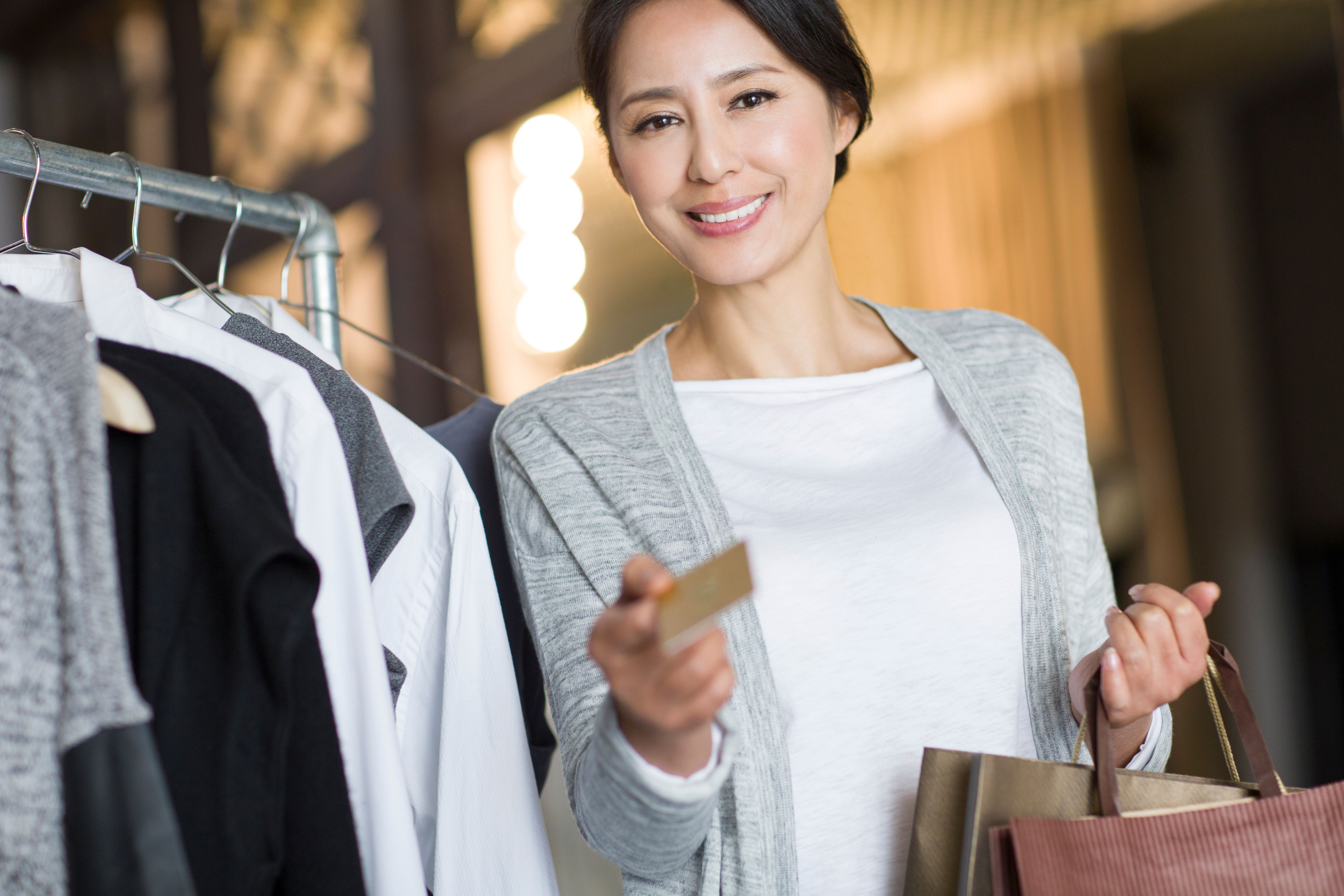 Picture of a woman with credit card near clothes 