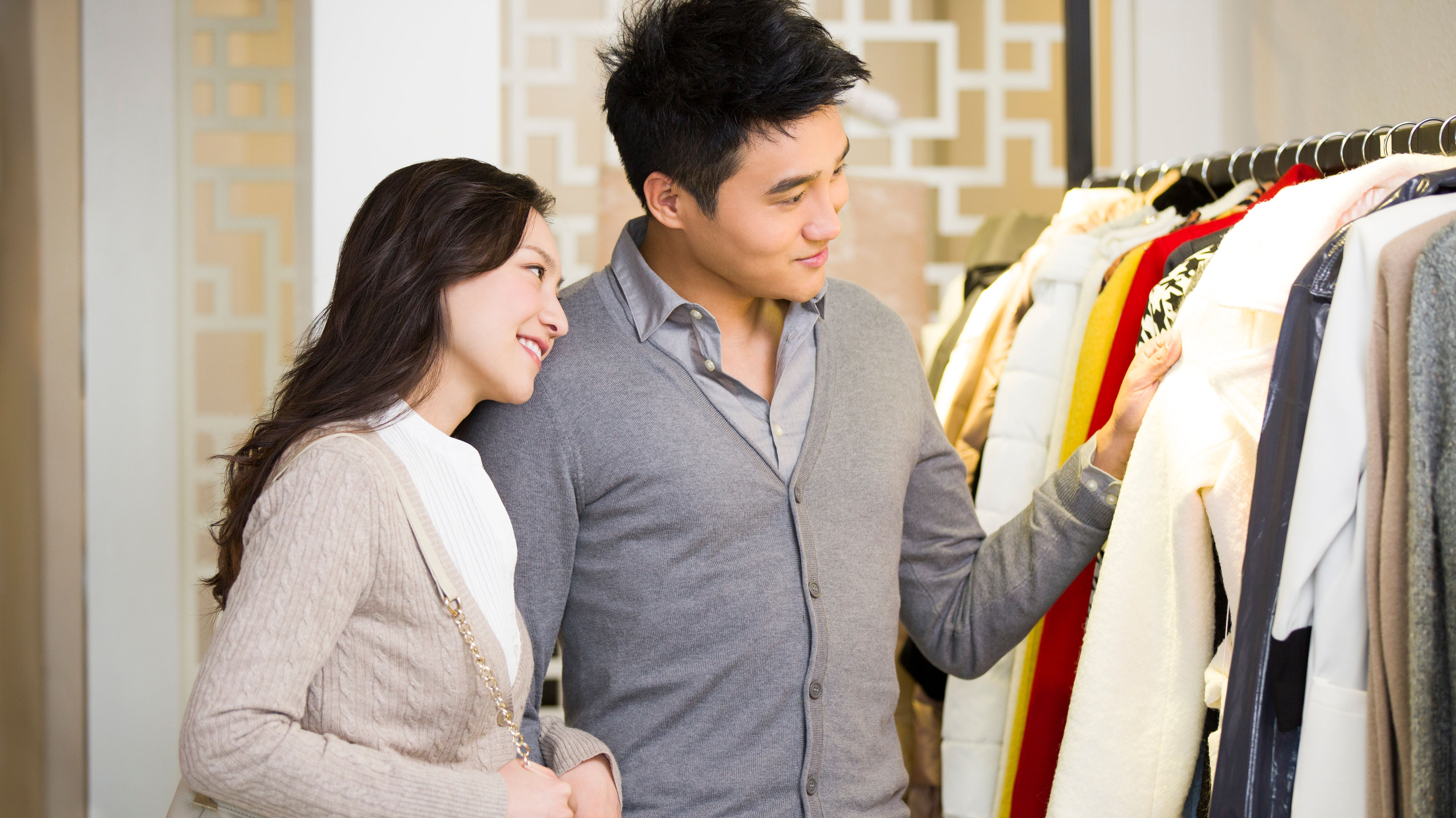 Young Chinese couple shopping for clothes in store