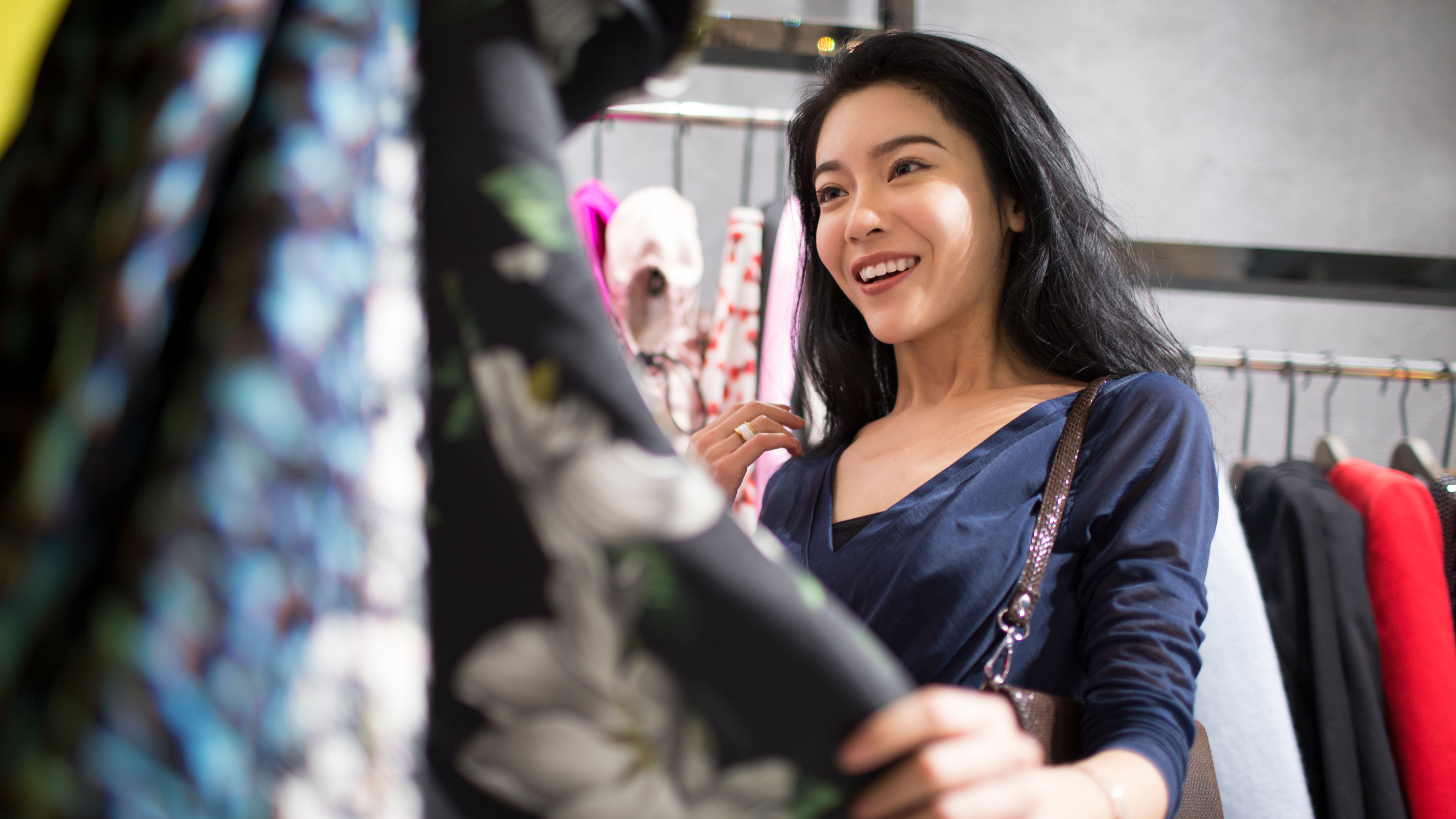 A young woman browsing and shopping in a trendy clothing store.